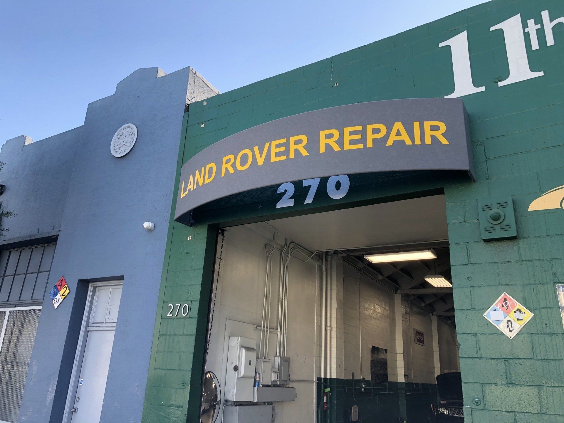 A green building with a sign that says land rover repair 270