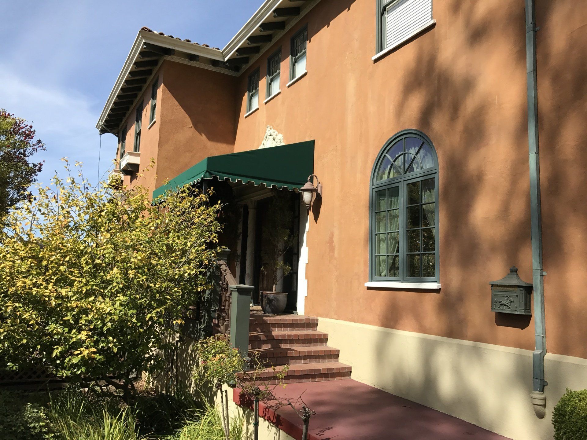 A large brown building with a green awning over the entrance.