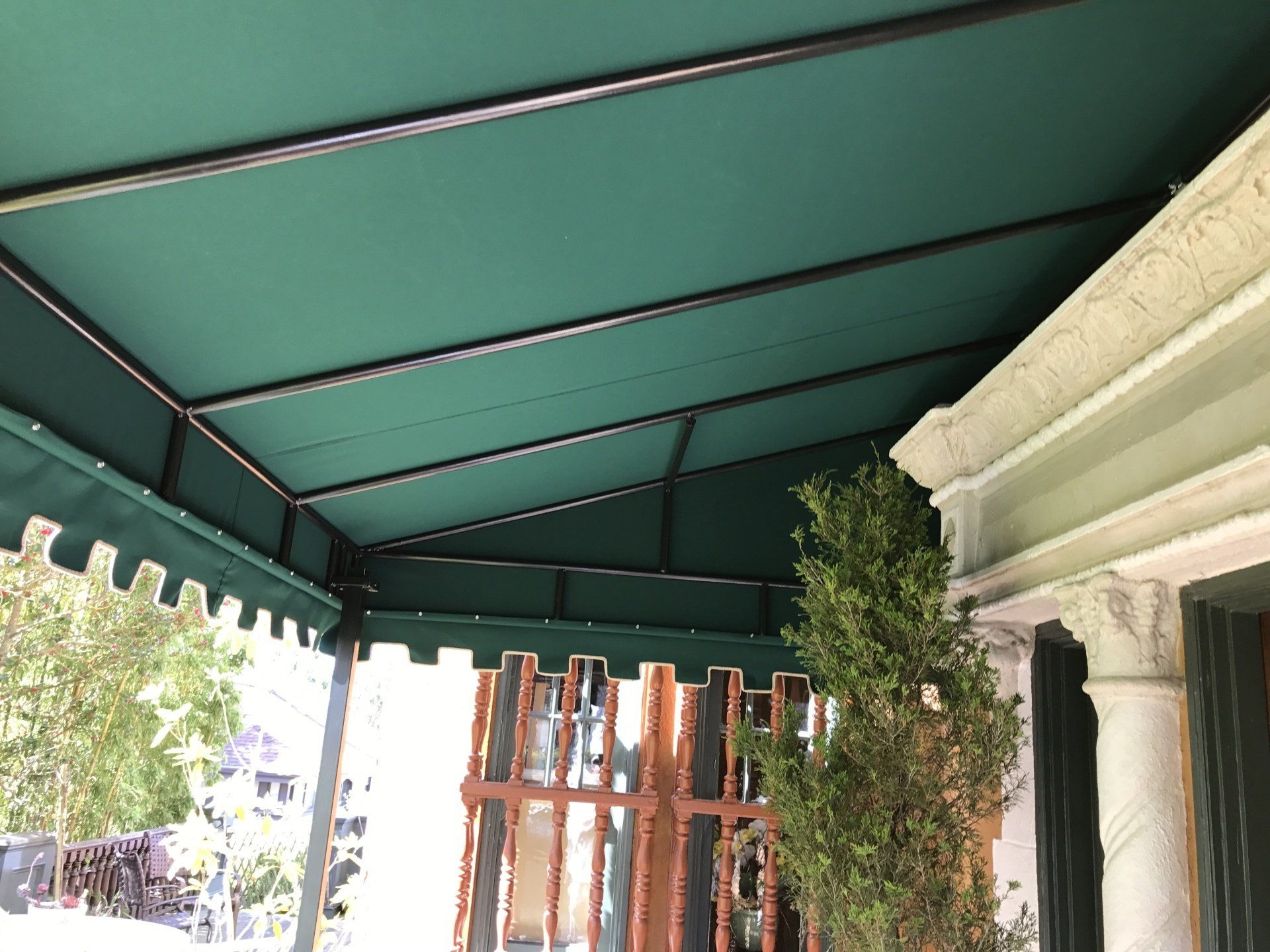 A green awning is on the side of a building