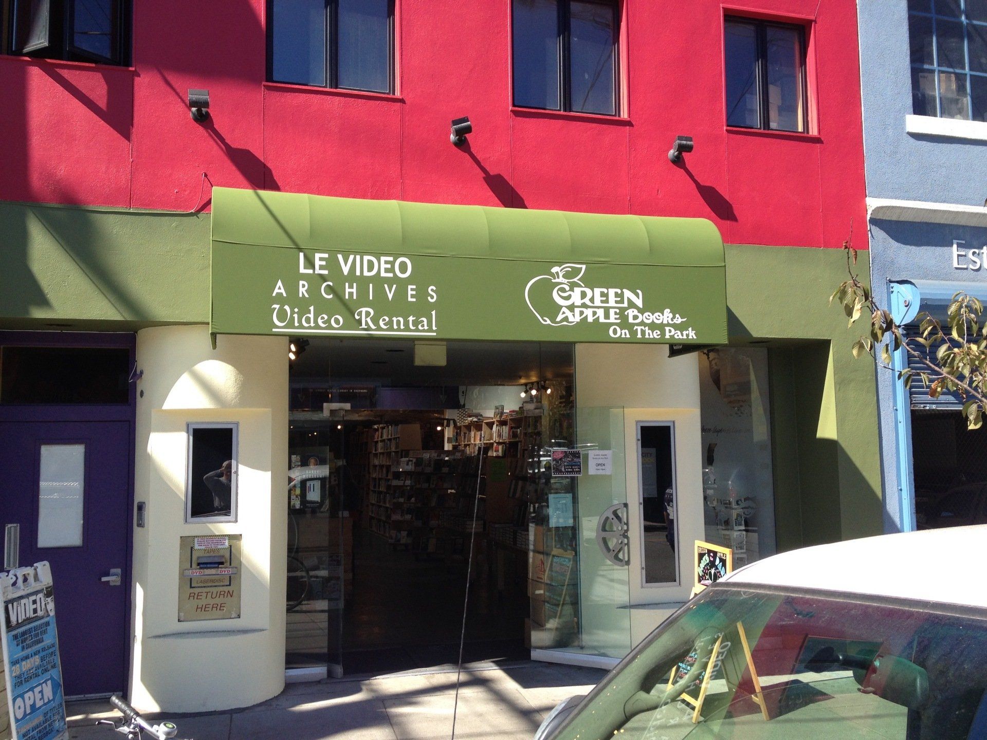 A red building with a green awning that says le video archives
