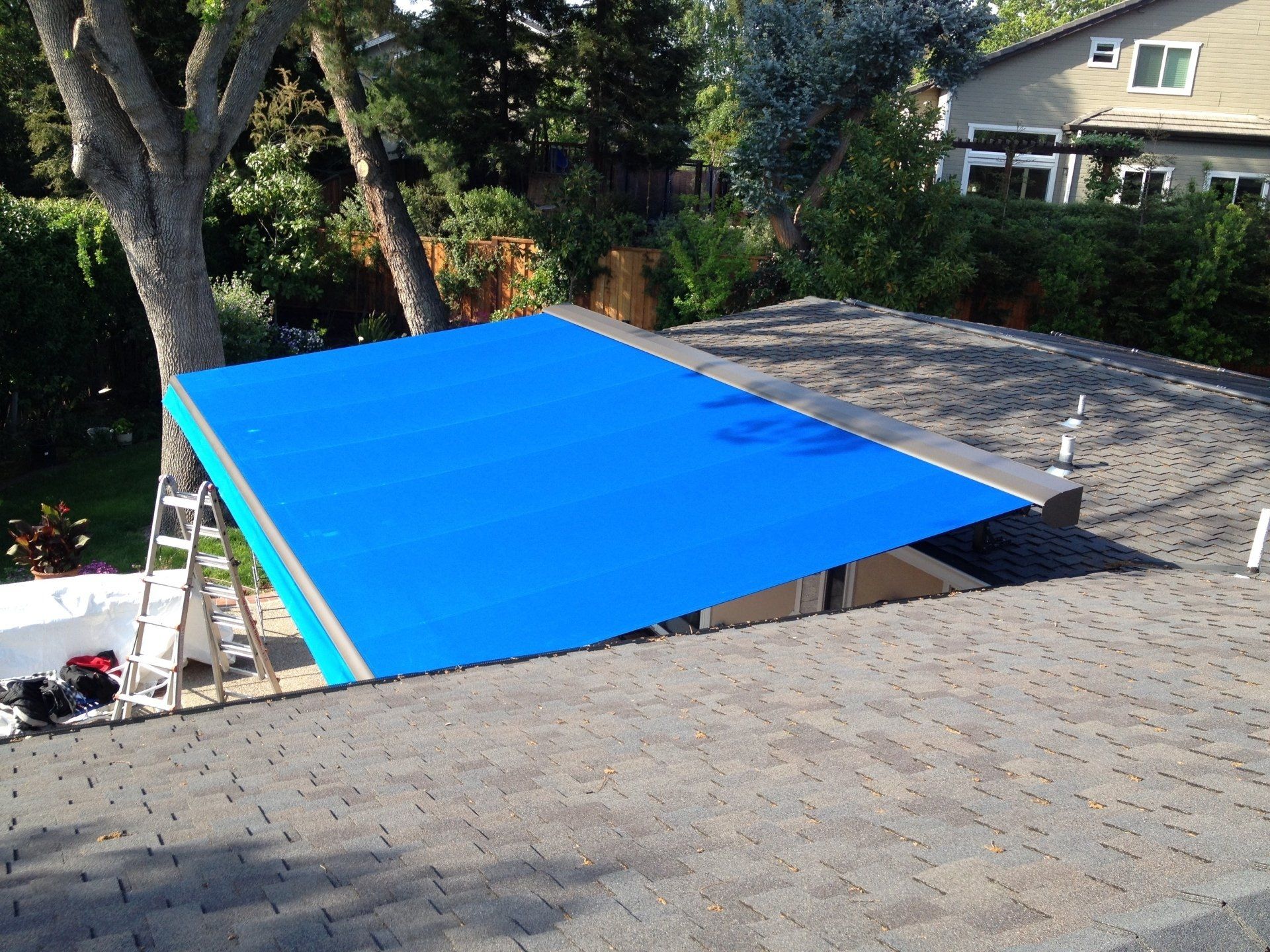 A blue tarp is covering the roof of a house