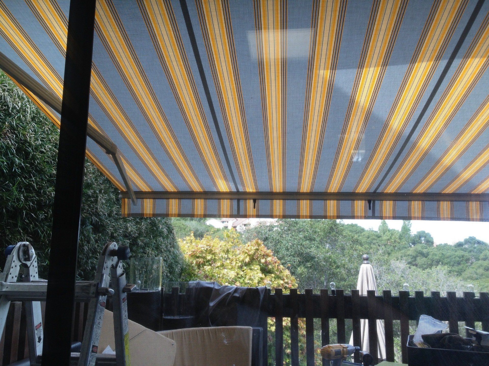 A balcony with a striped awning over it