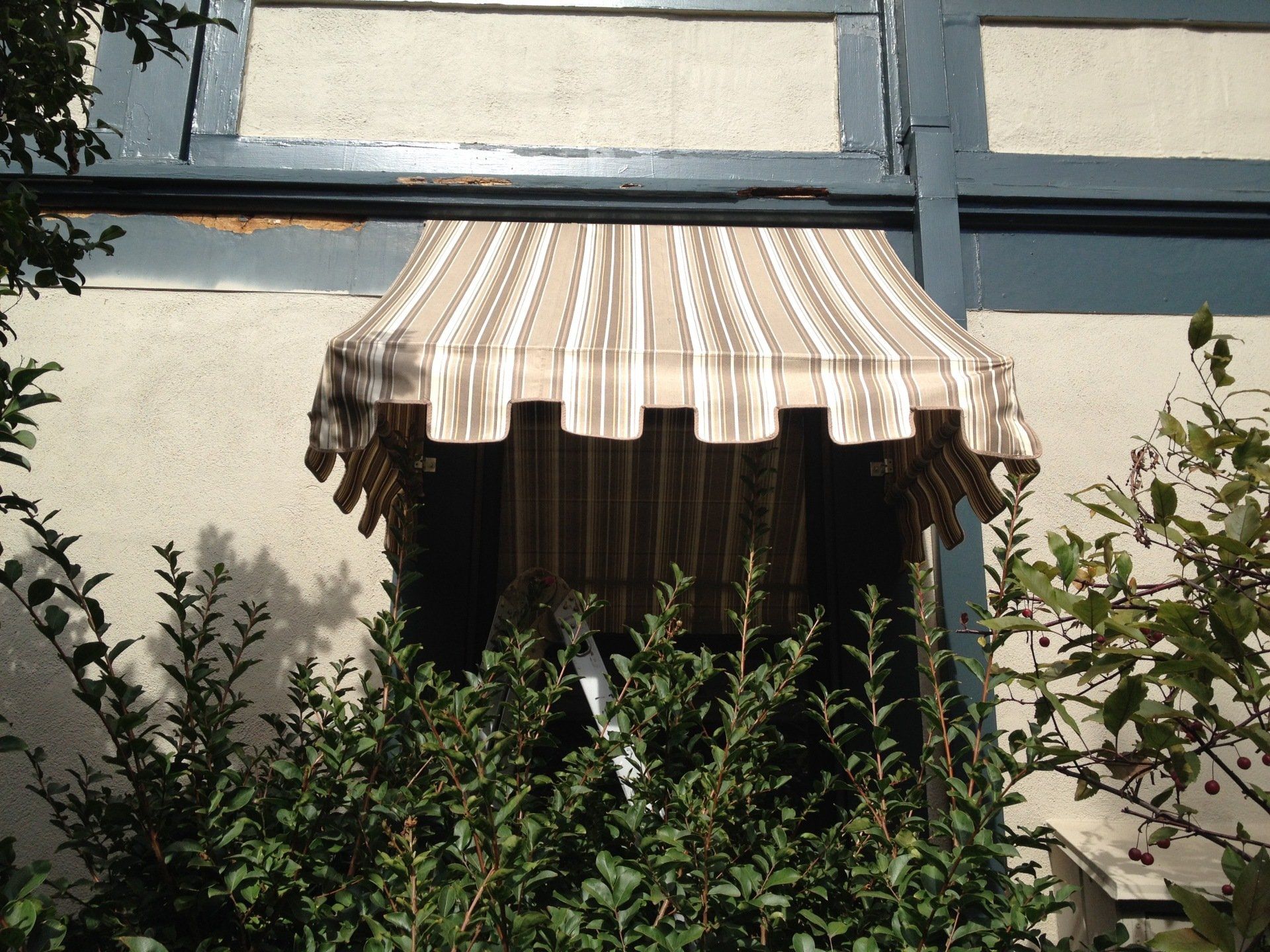 A striped awning is hanging from the side of a building