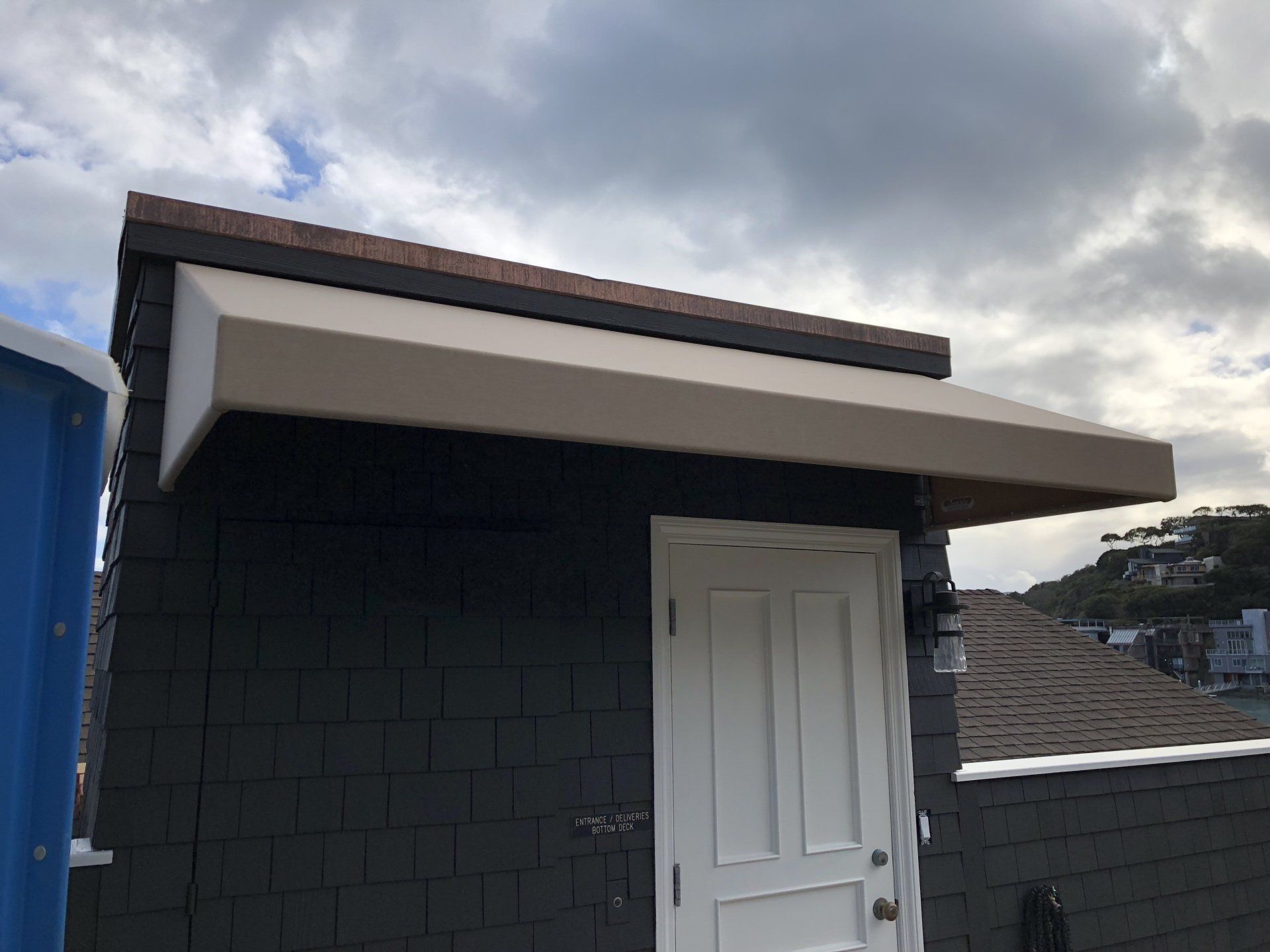A white door with a canopy over it is on the side of a building.