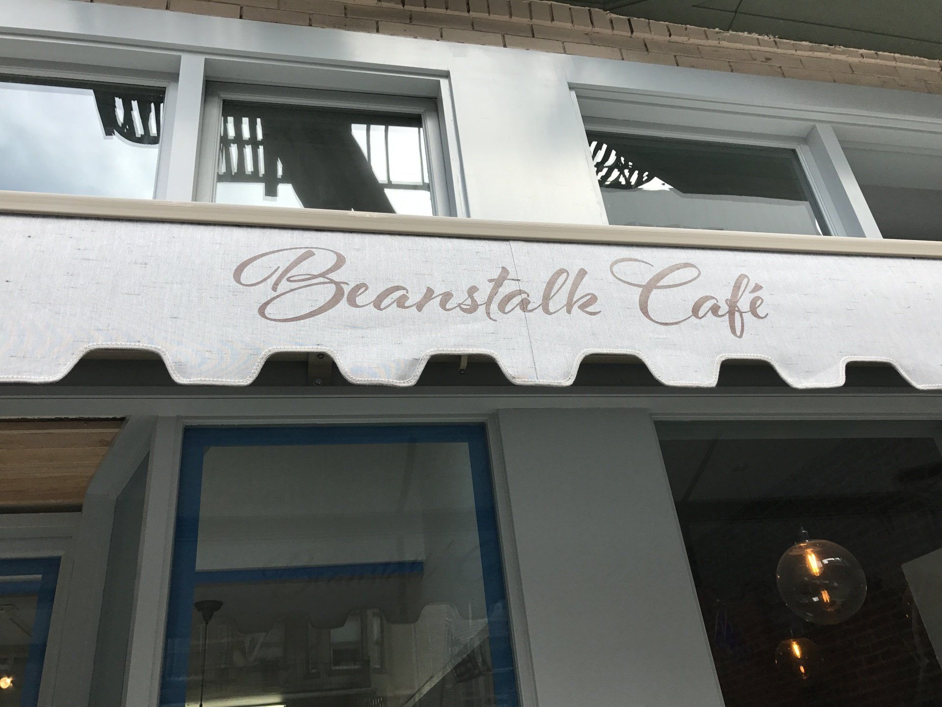 A white awning with the words beanstalk cafe on it