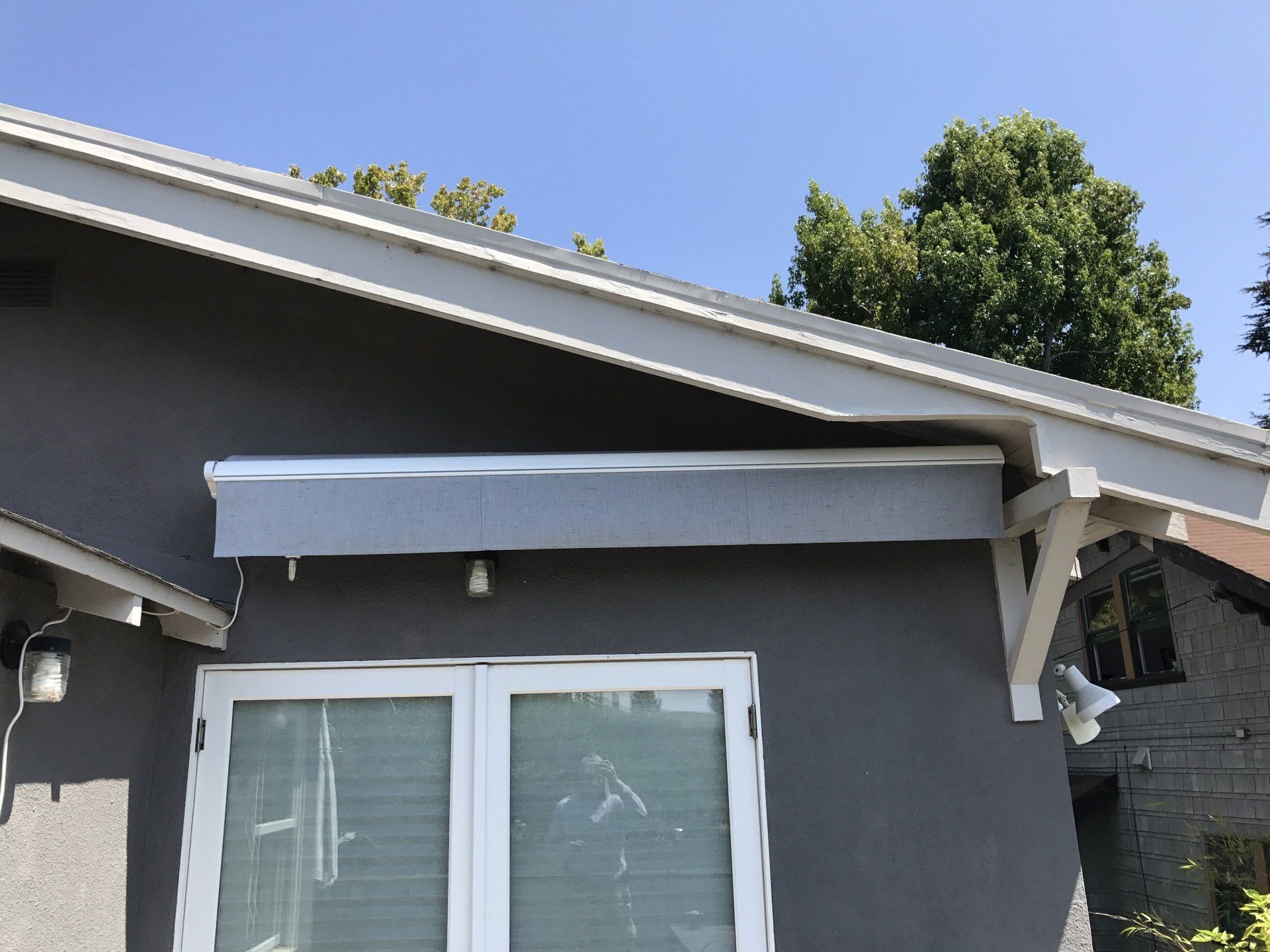 A gray house with a white window and a white roof