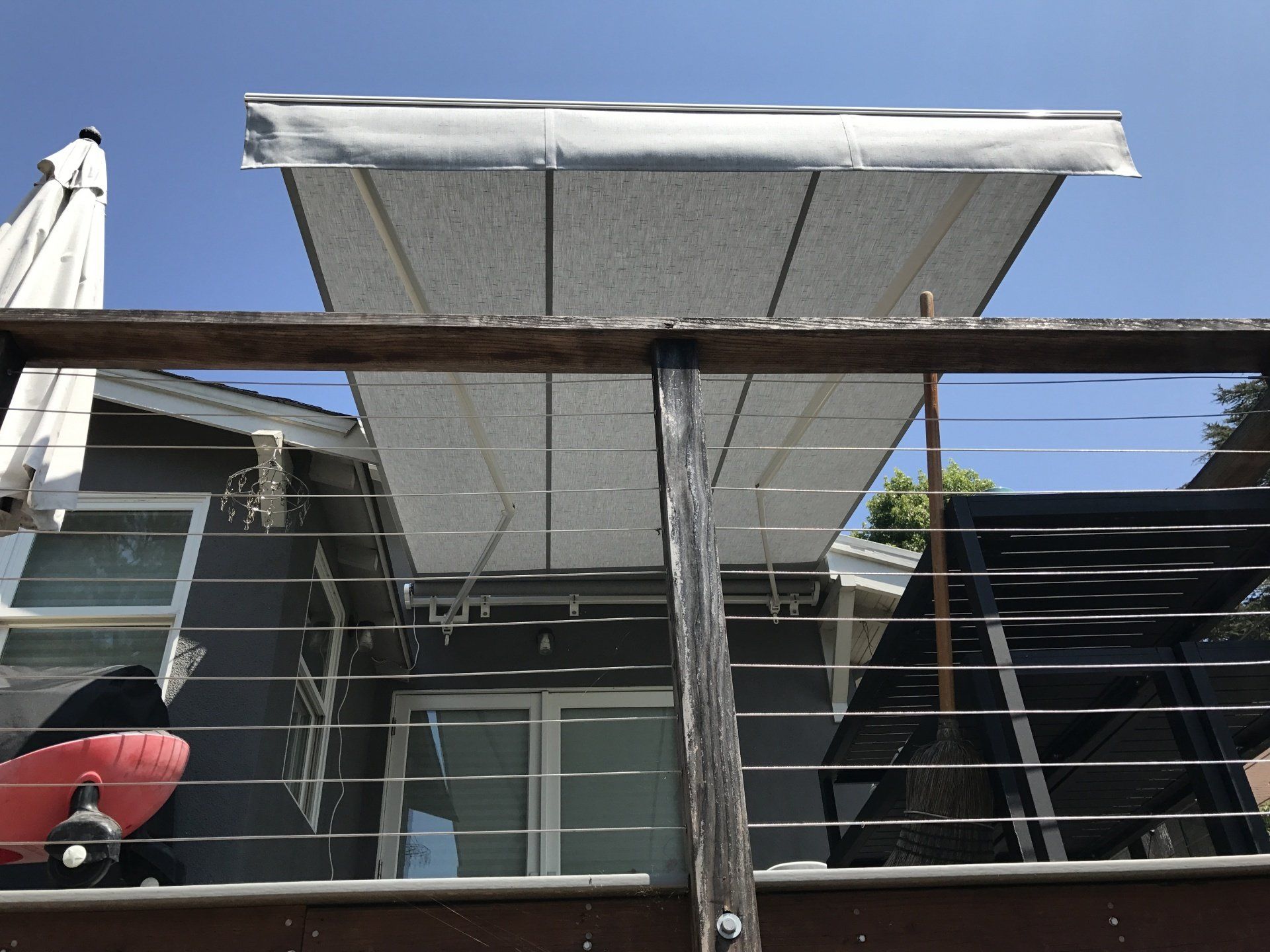 A balcony with a white awning and a surfboard on it.