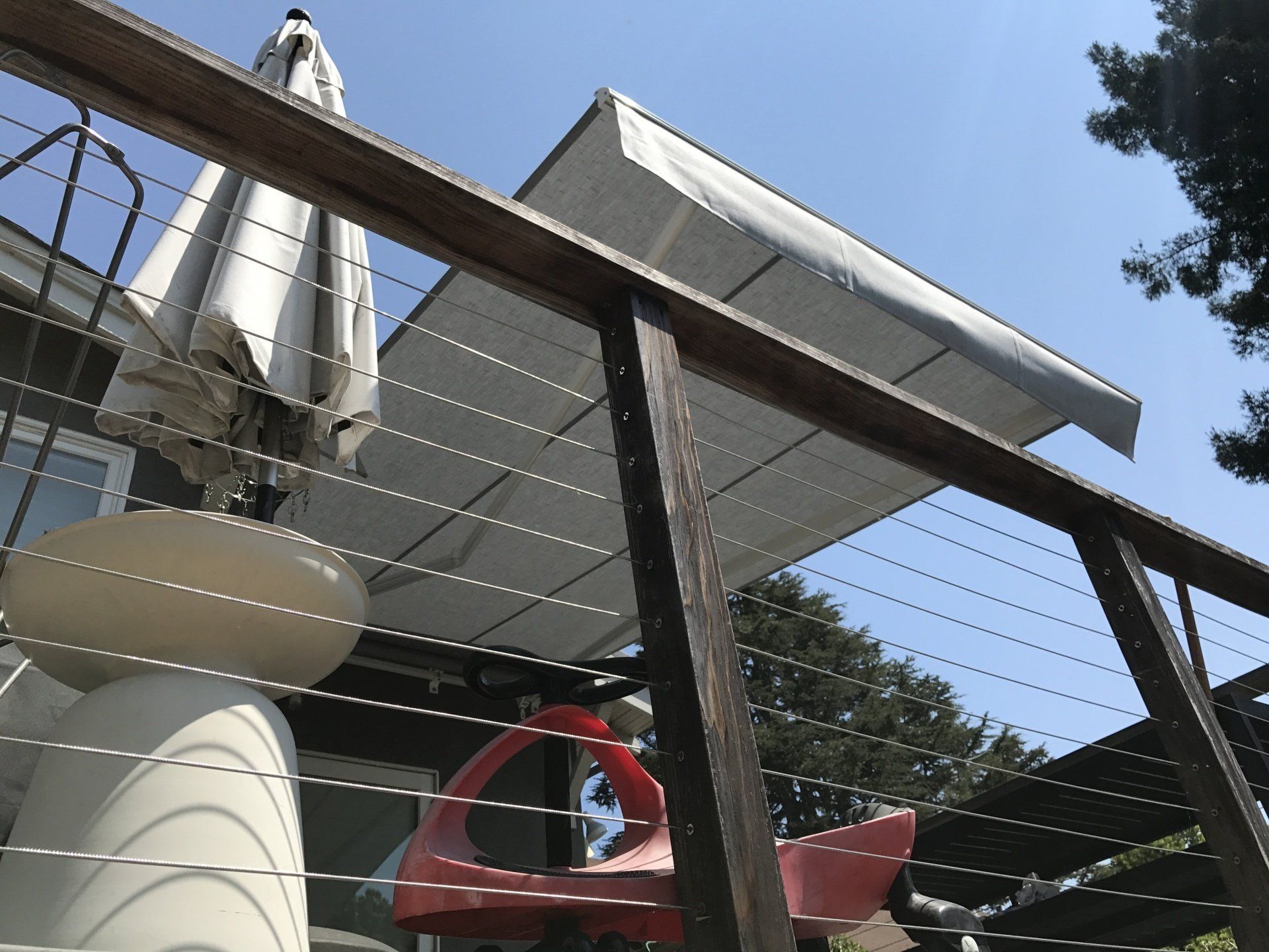A deck with a white awning and a table