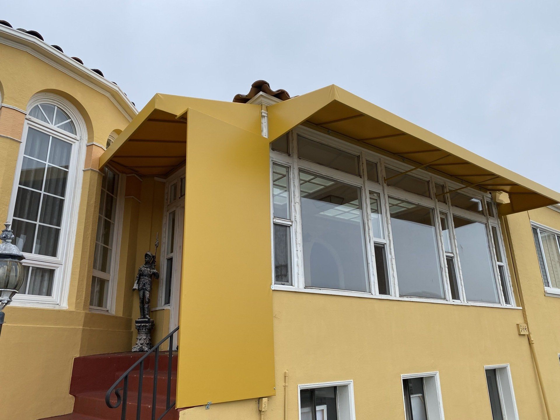 A yellow building with a canopy over the front door