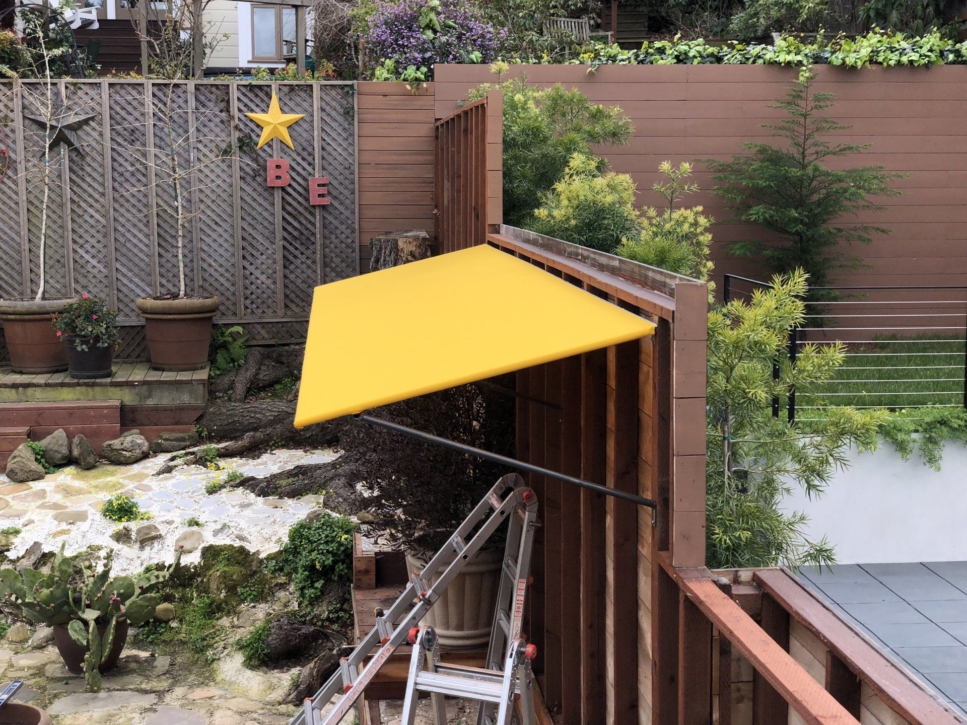 A yellow awning is hanging over a wooden fence