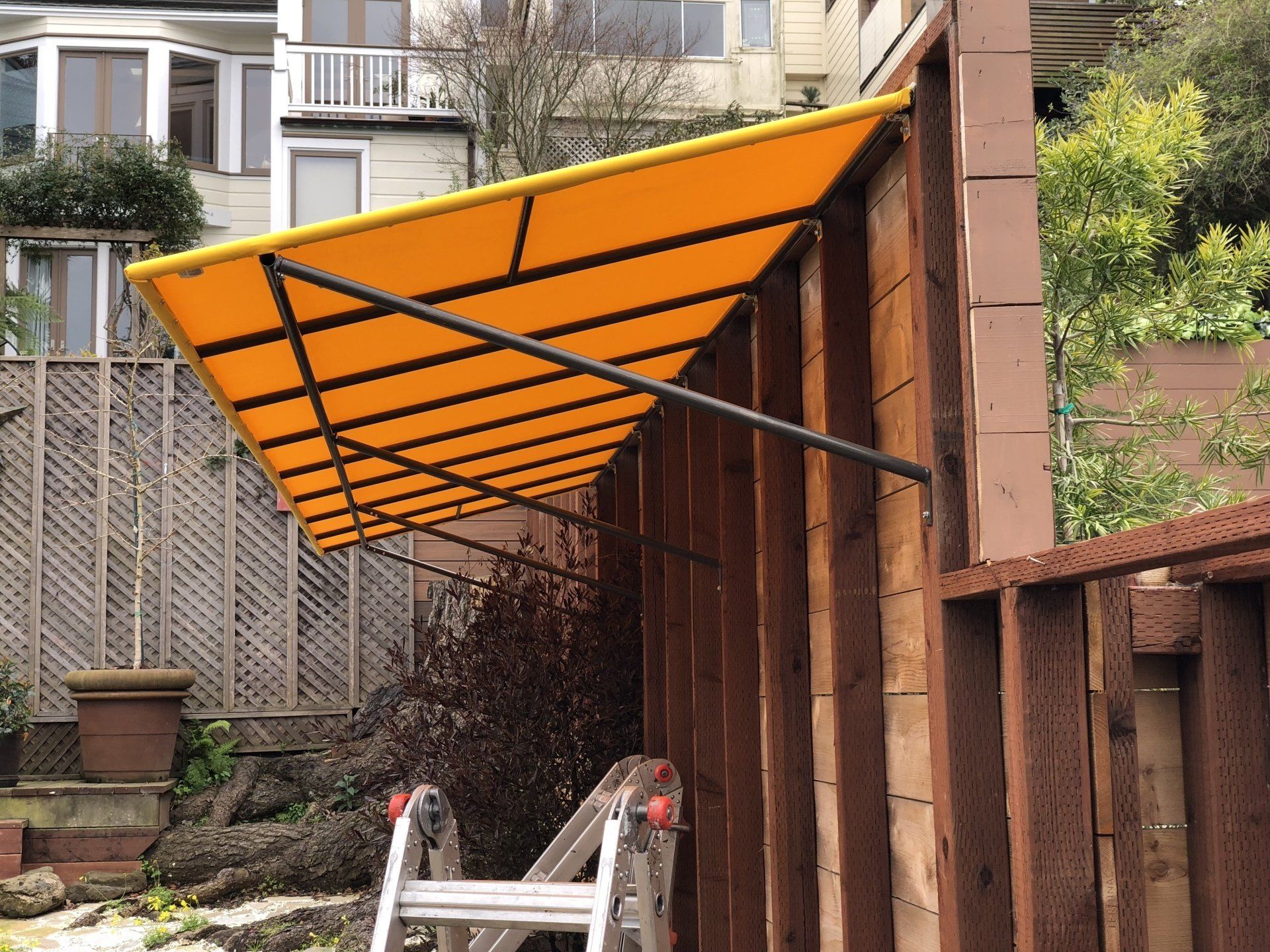 A yellow awning is attached to a wooden fence