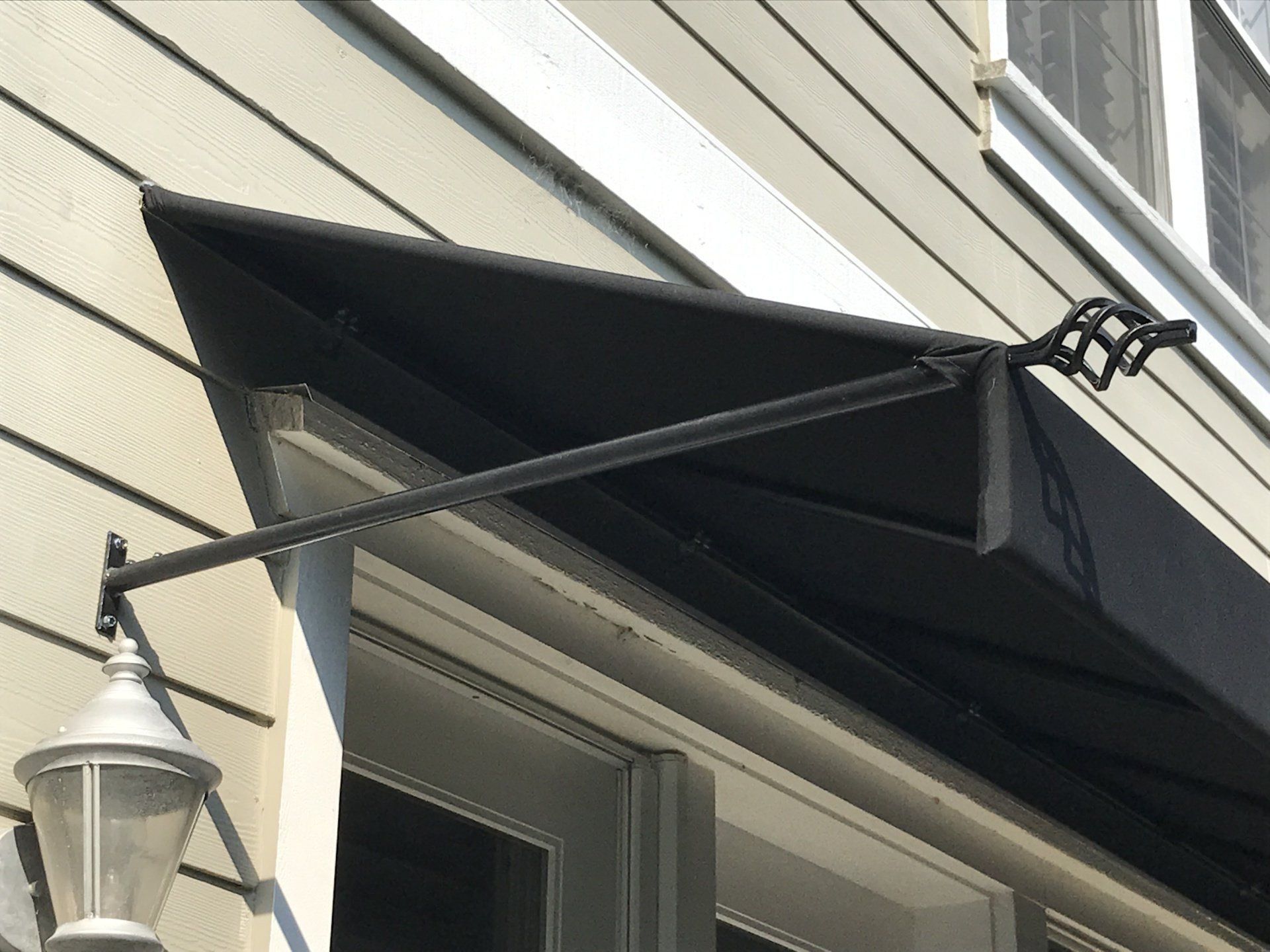 A black awning is attached to the side of a building