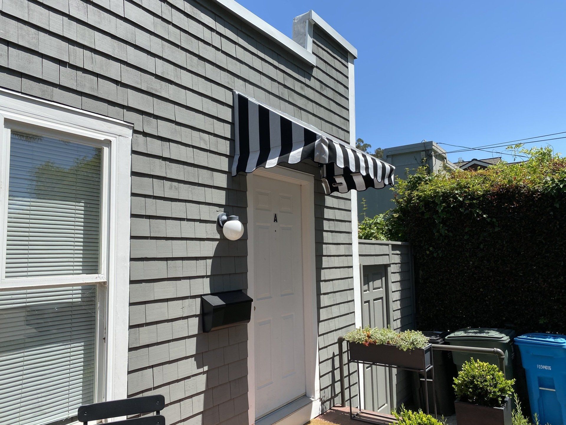 A house with a black and white awning over the door