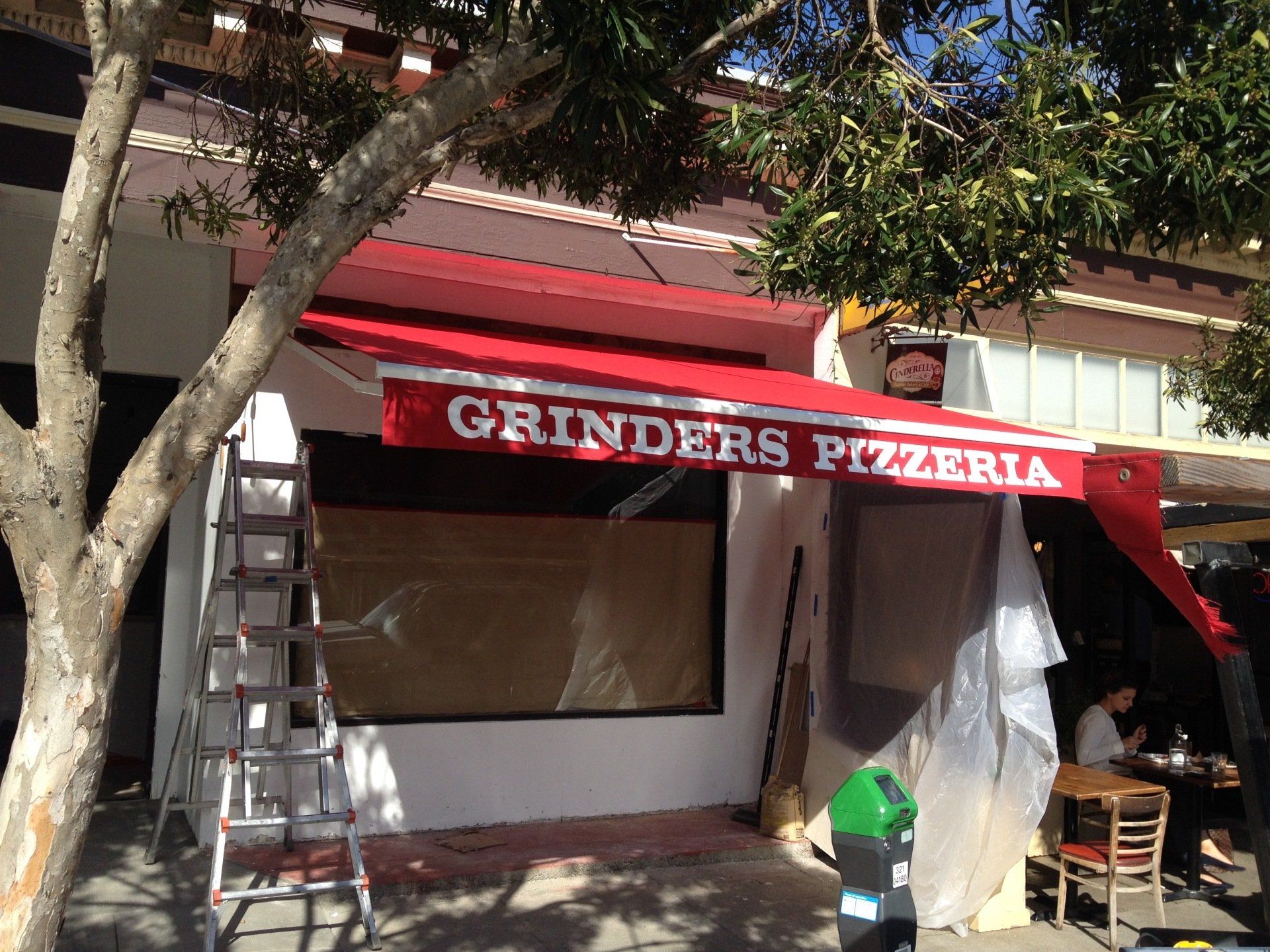 A red awning with grinders pizzeria written on it