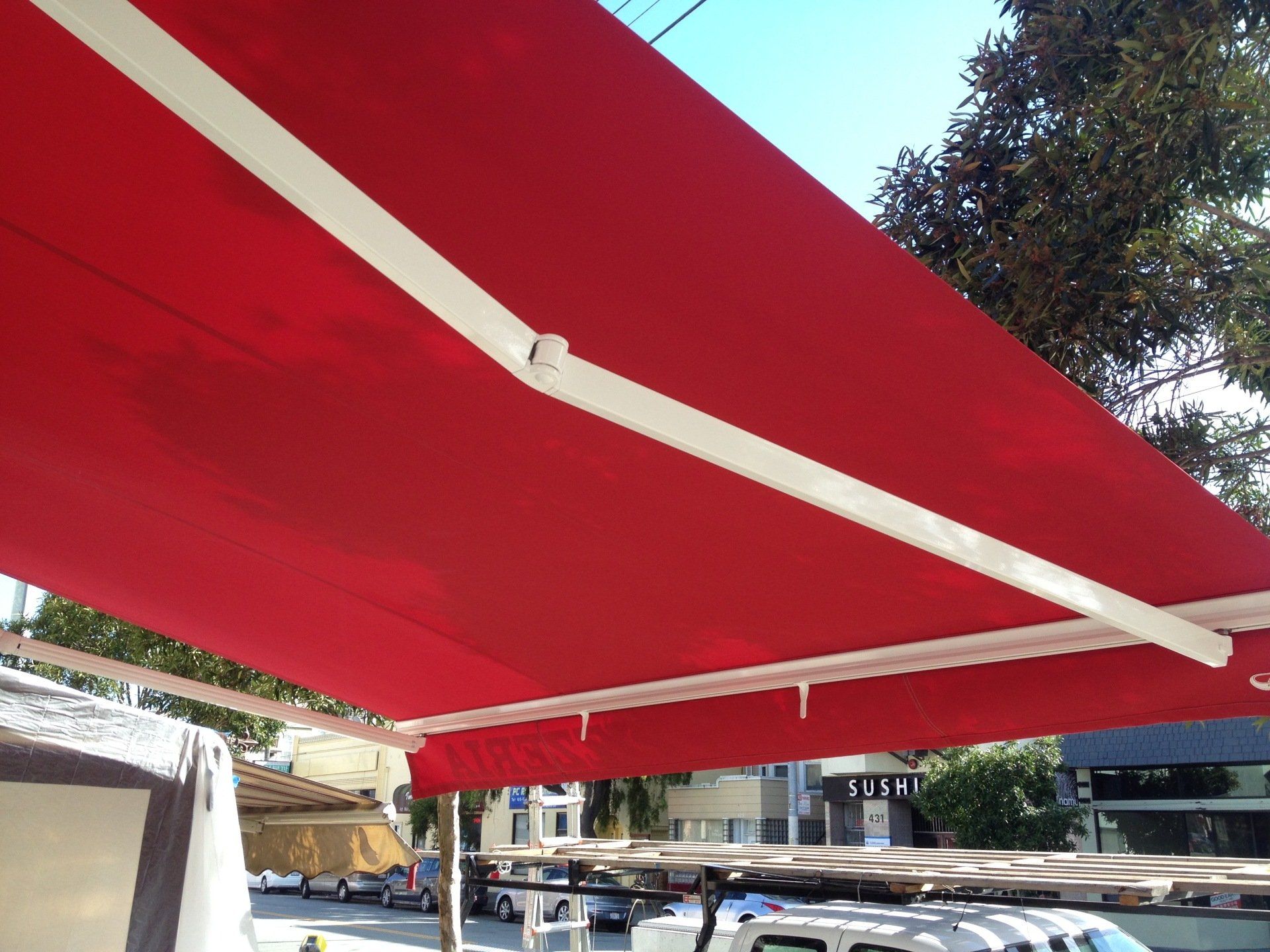 A red awning is hanging over a parking lot