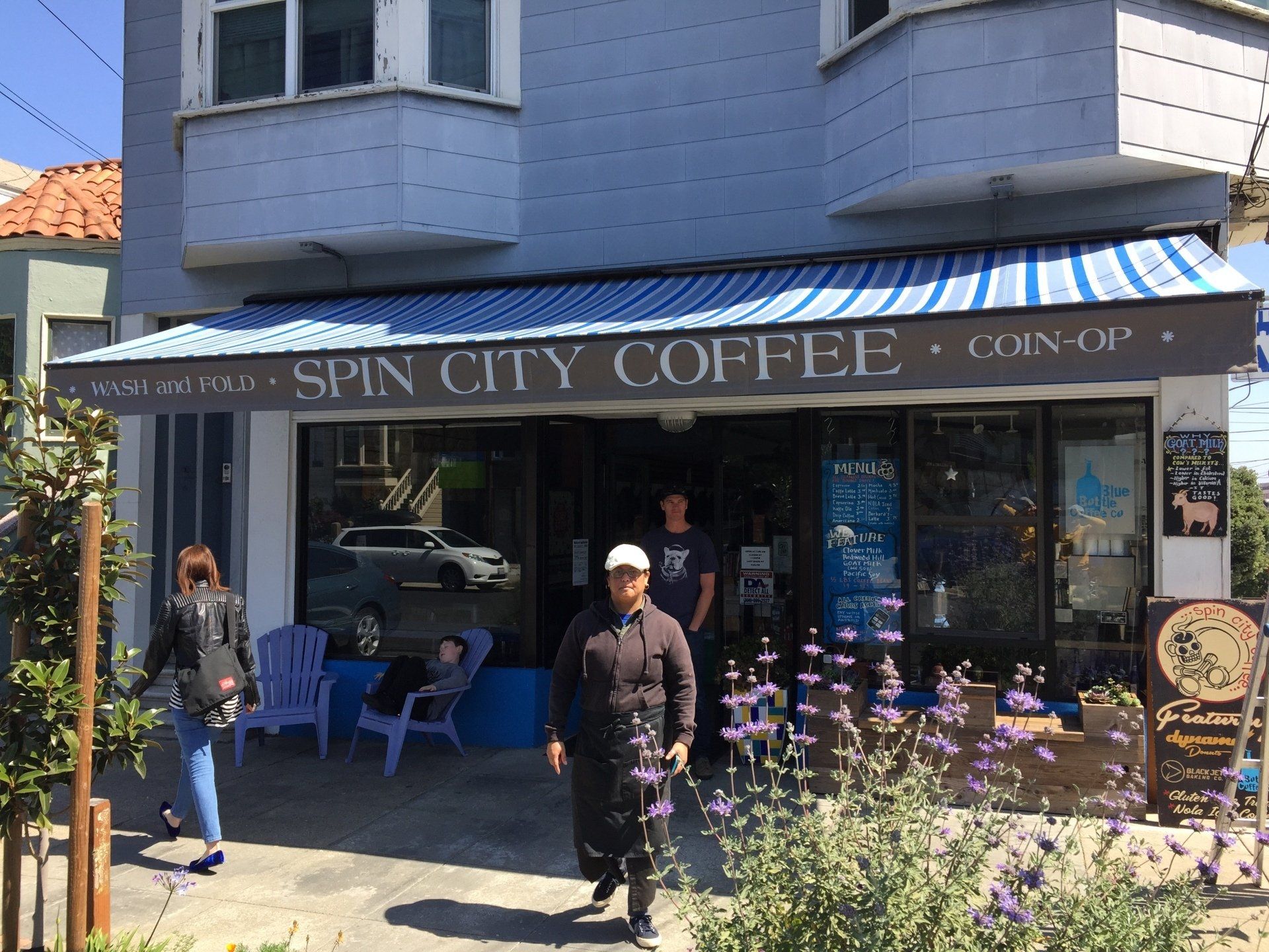 A man standing in front of a spin city coffee shop