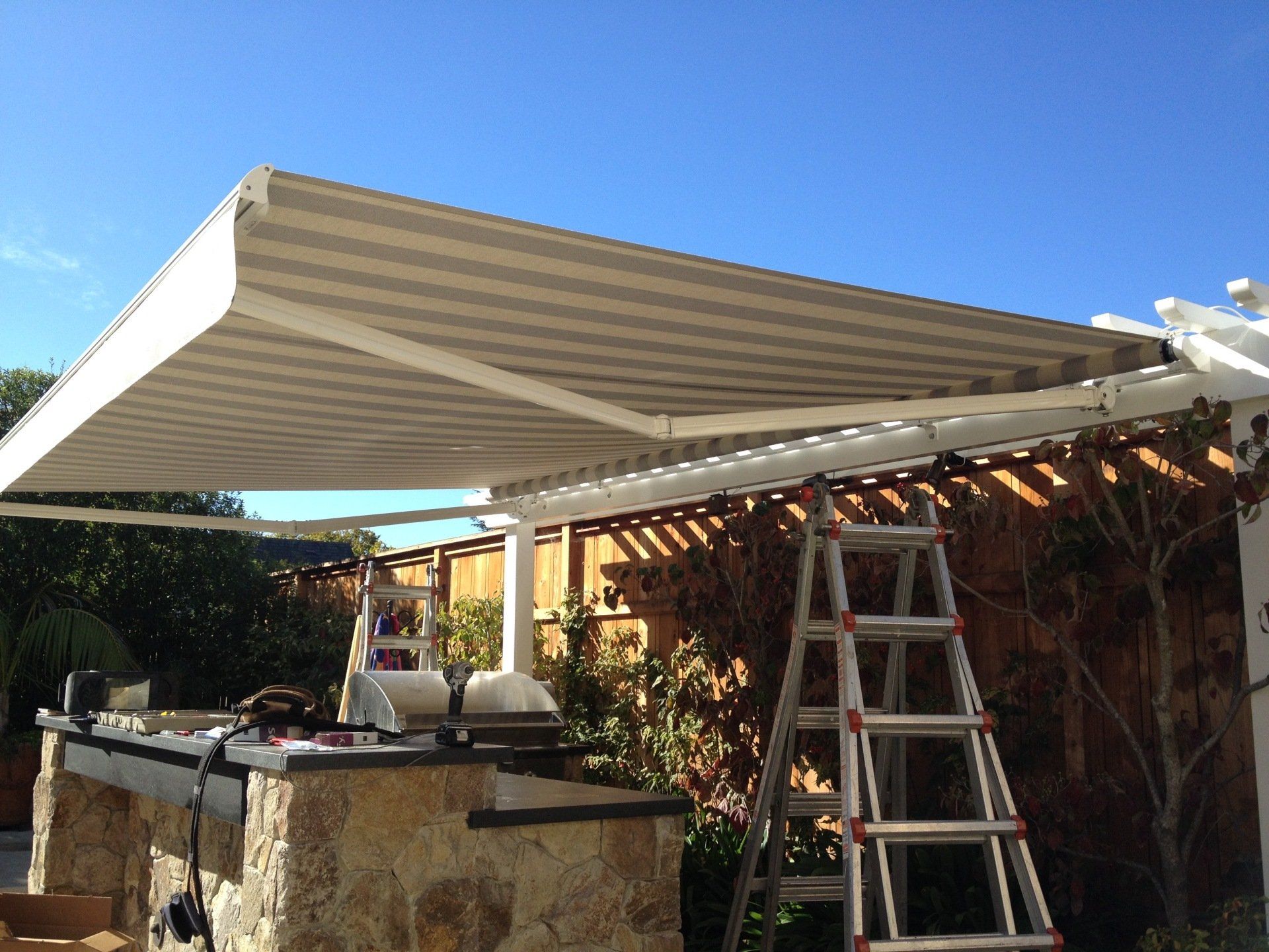 A ladder is sitting under an awning over a kitchen