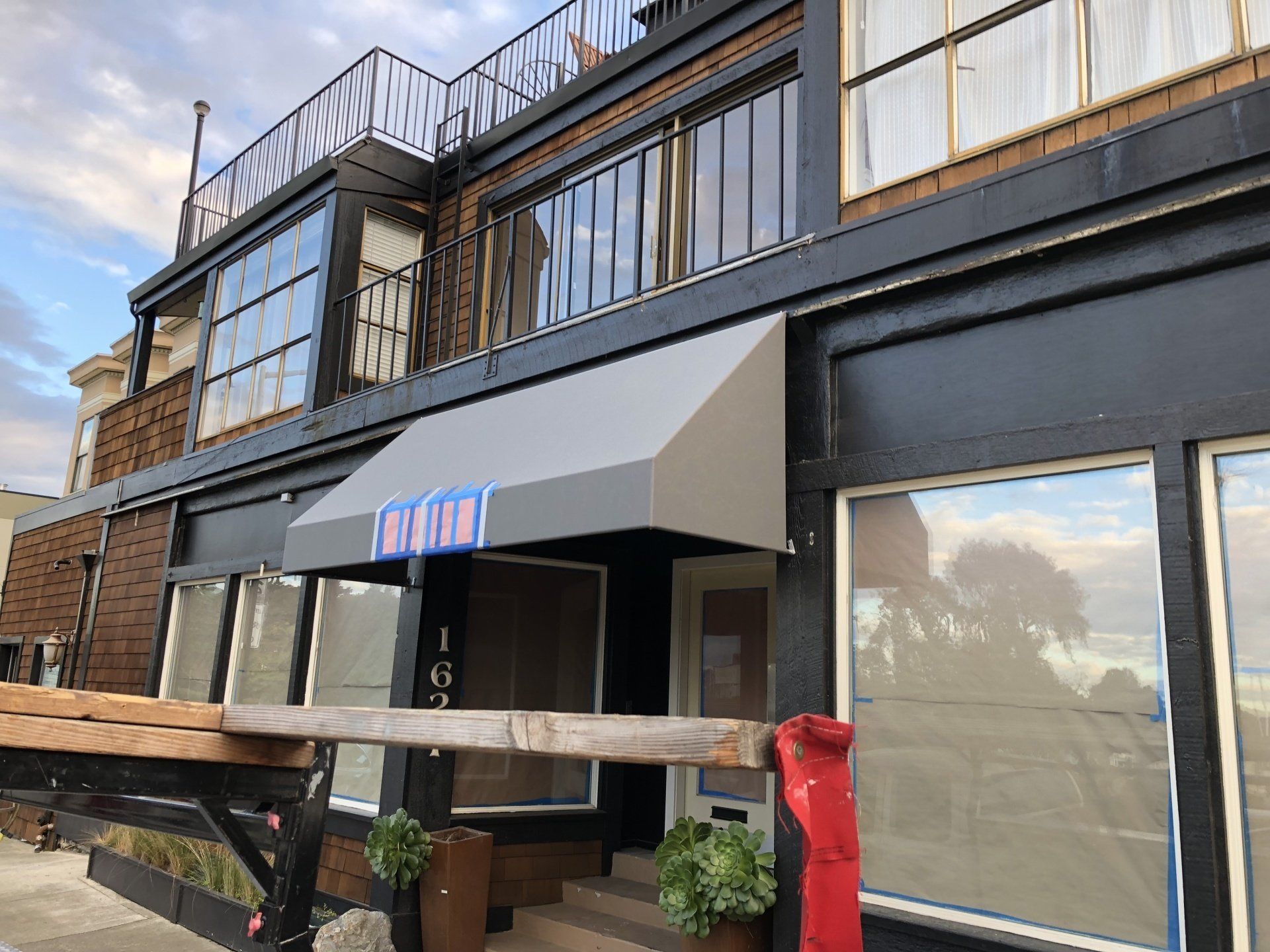 The front of a building with a canopy and a balcony.