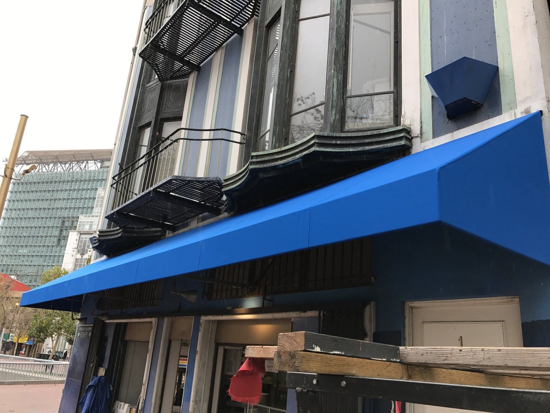 A blue awning is on the side of a building