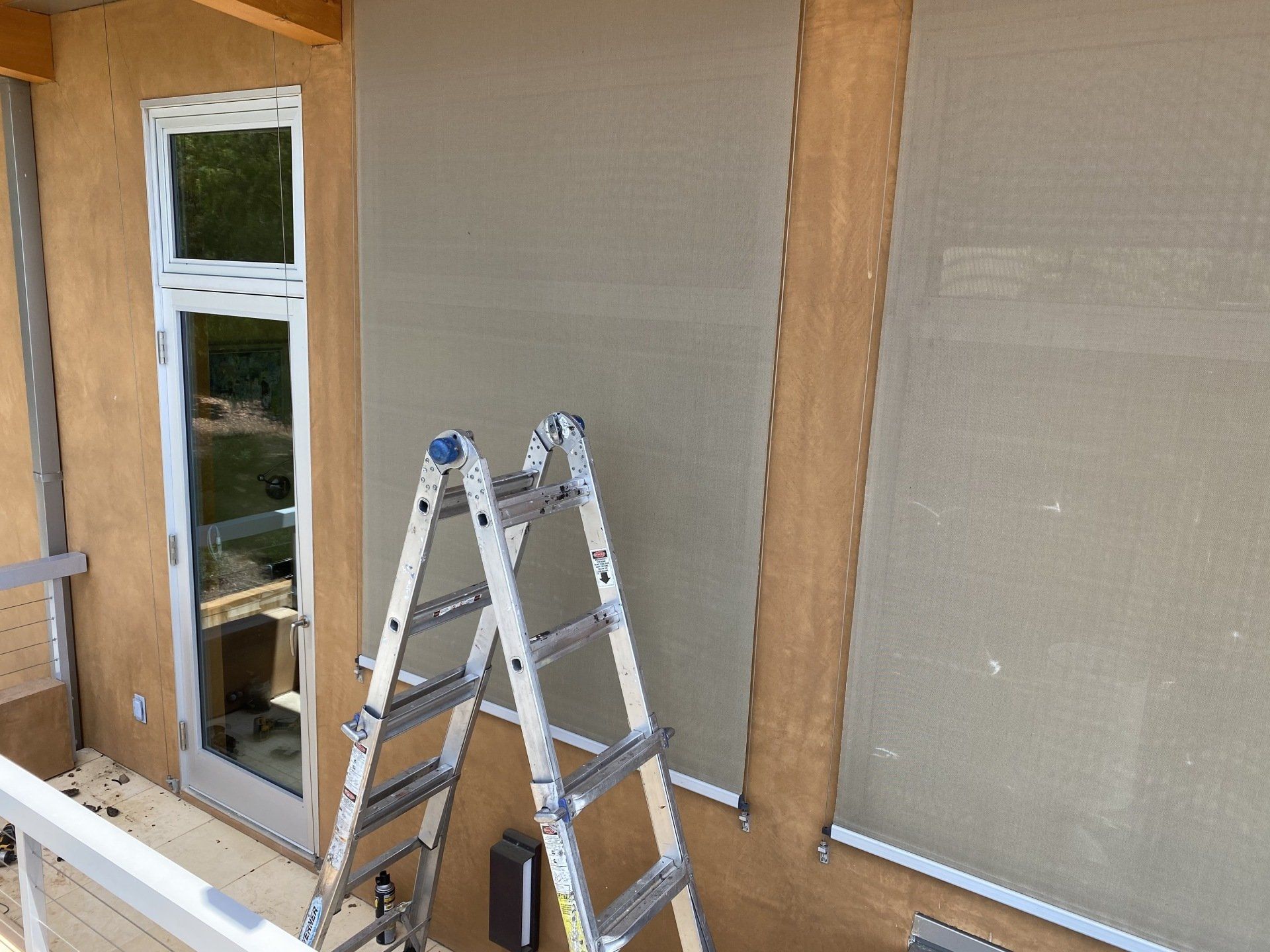 A ladder is leaning against a wall next to a window.