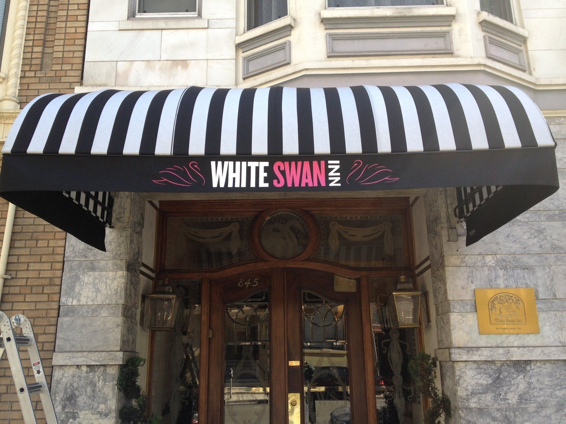 A black and white awning over the entrance to the white swan hotel
