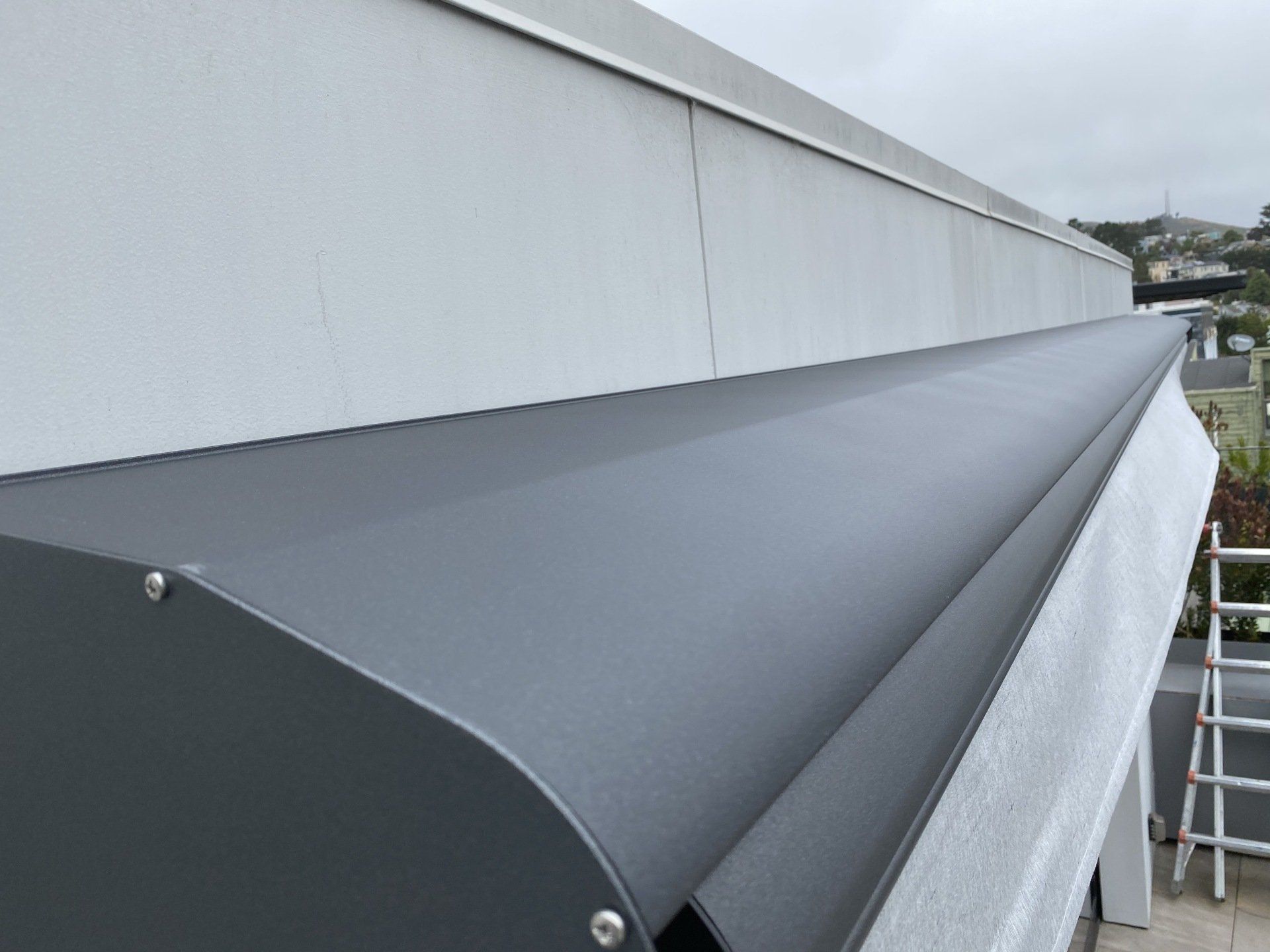A gray awning is on the side of a building.