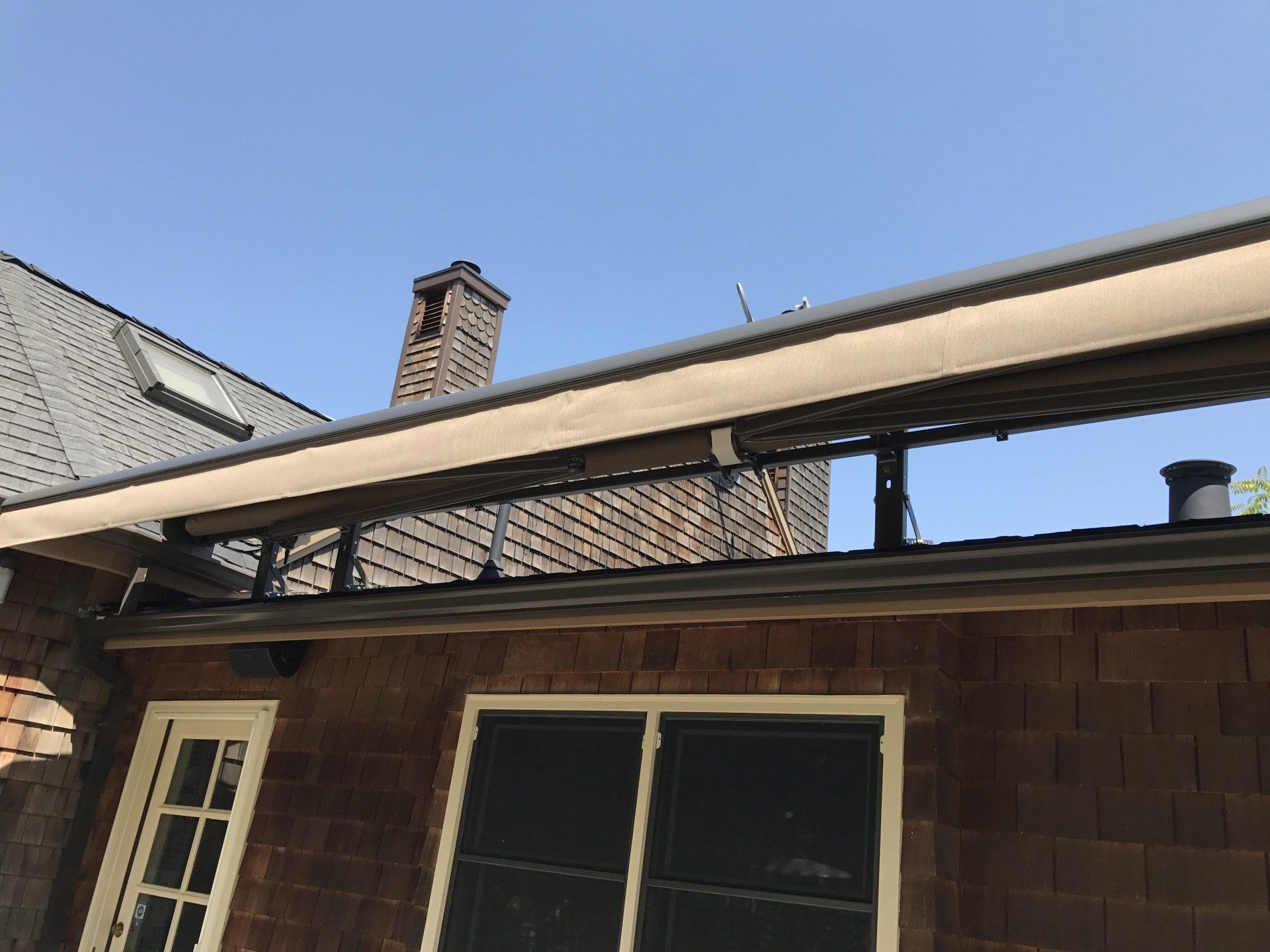 A house with a roof that has an awning on it