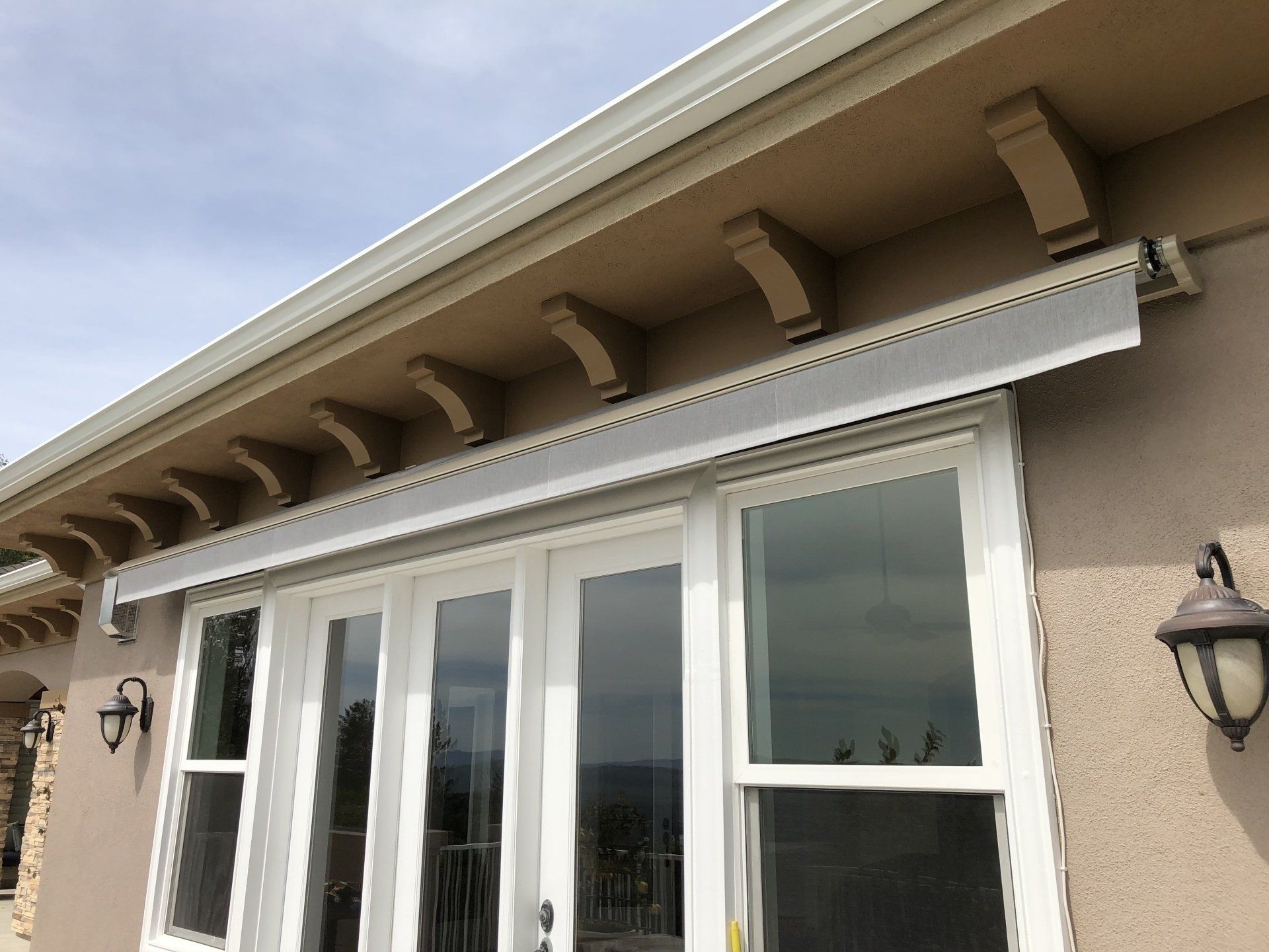 A house with a white awning over a sliding glass door.