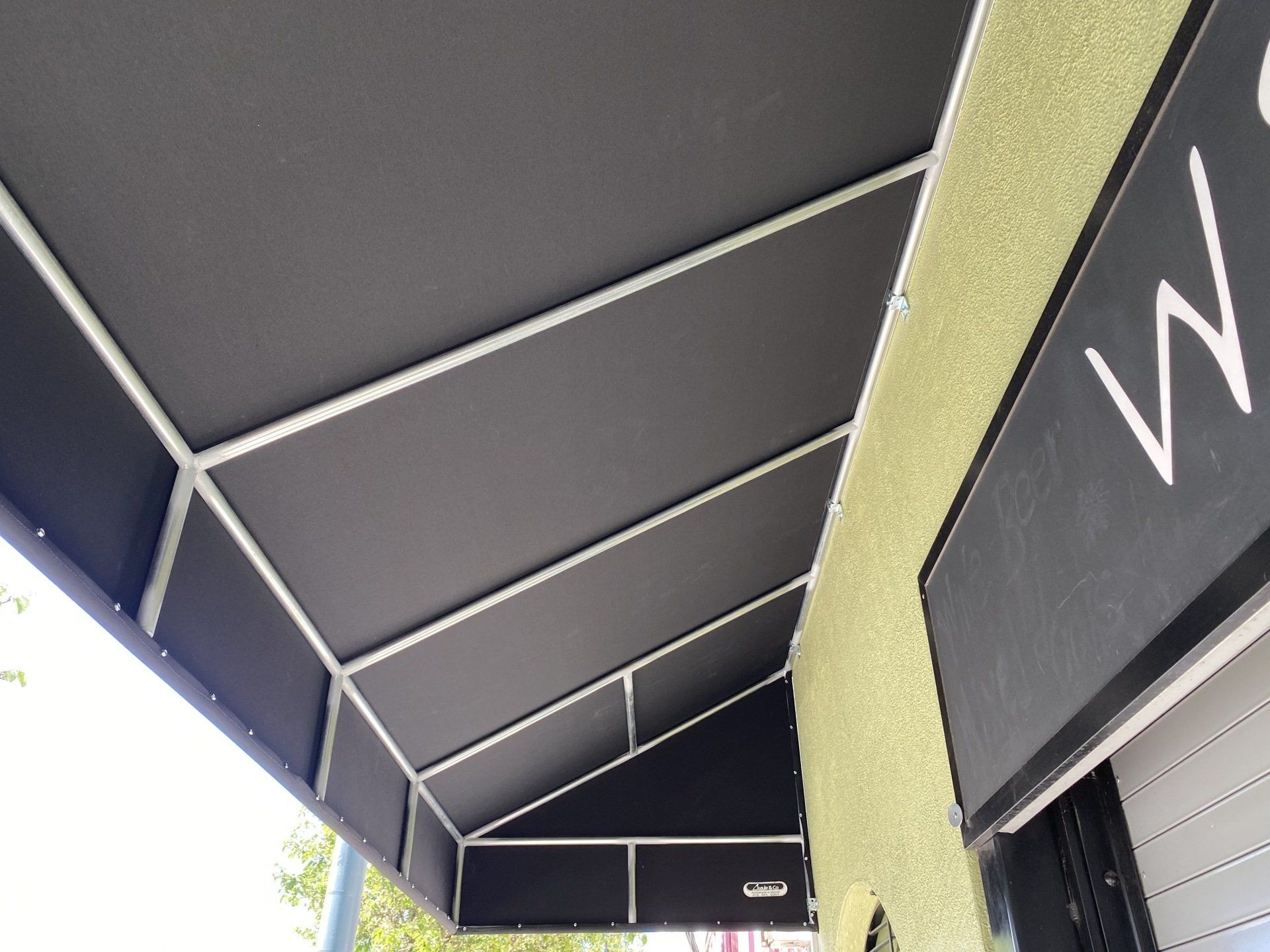 A black awning is on the side of a building