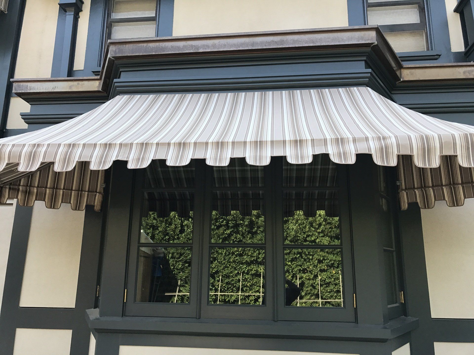 A window with a striped awning over it