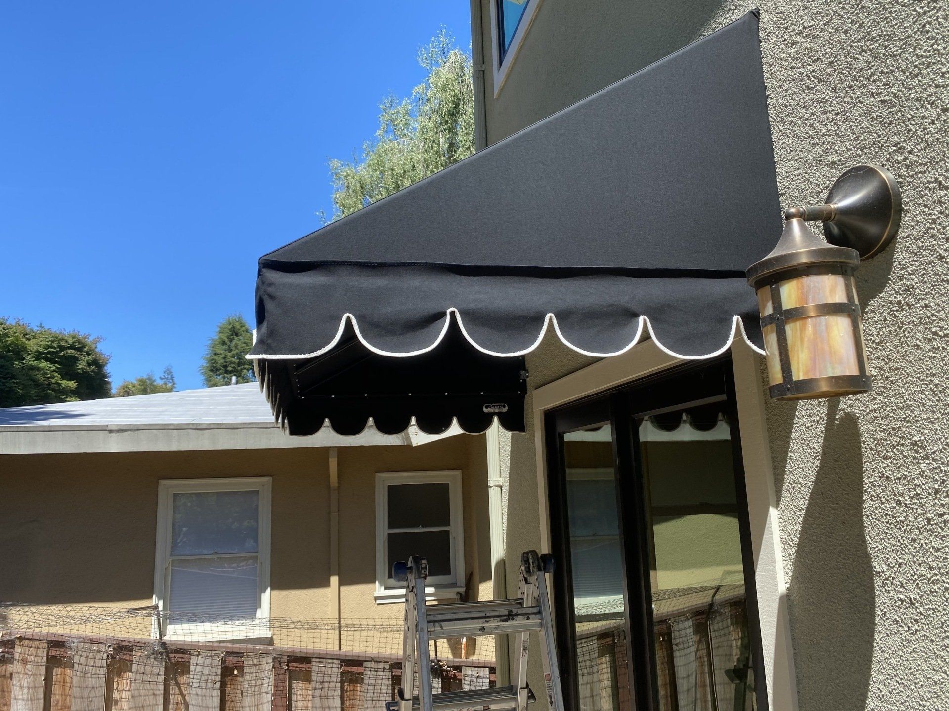 A black awning is attached to the side of a building.