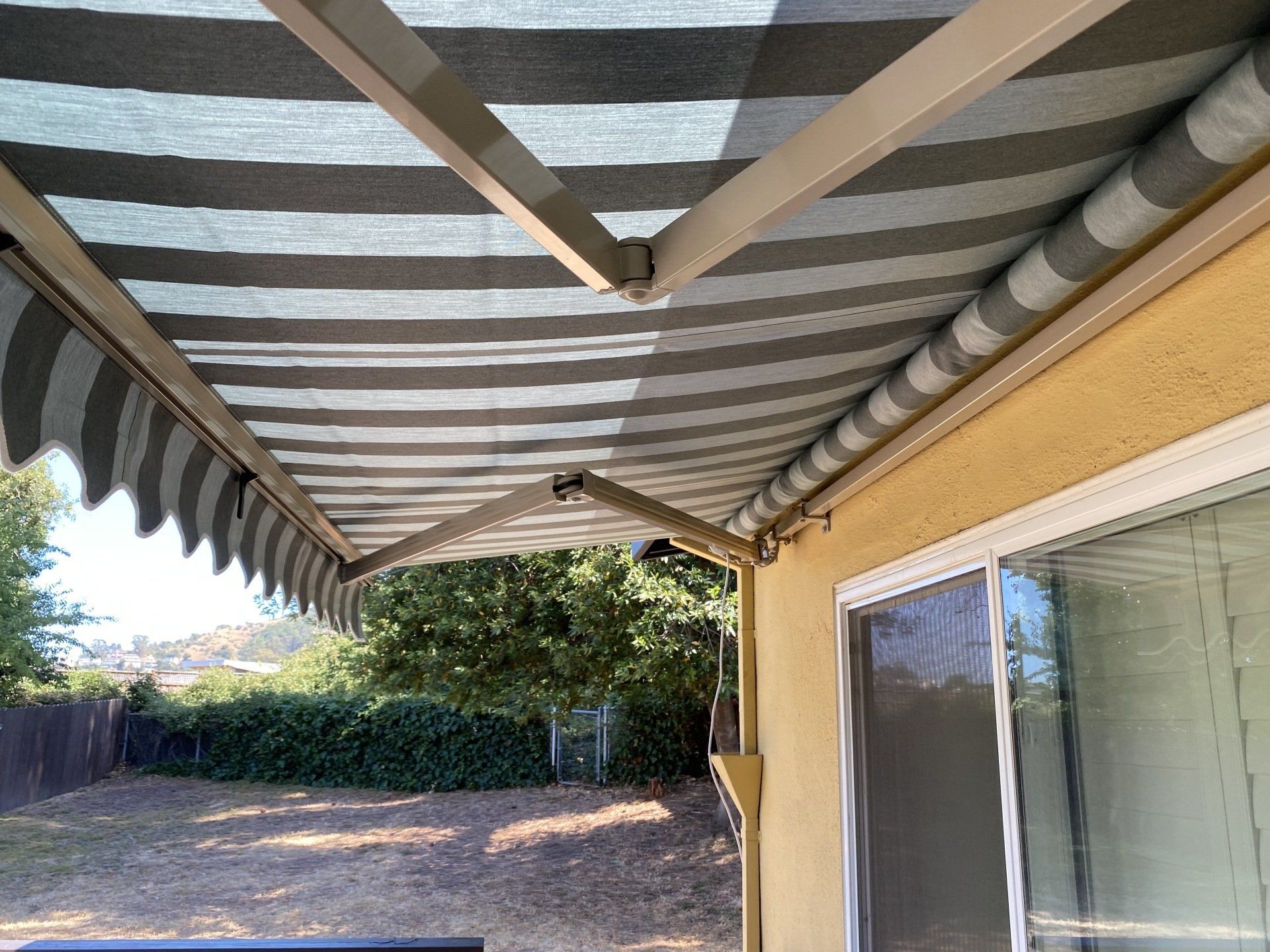 A striped awning is hanging over a sliding glass door.