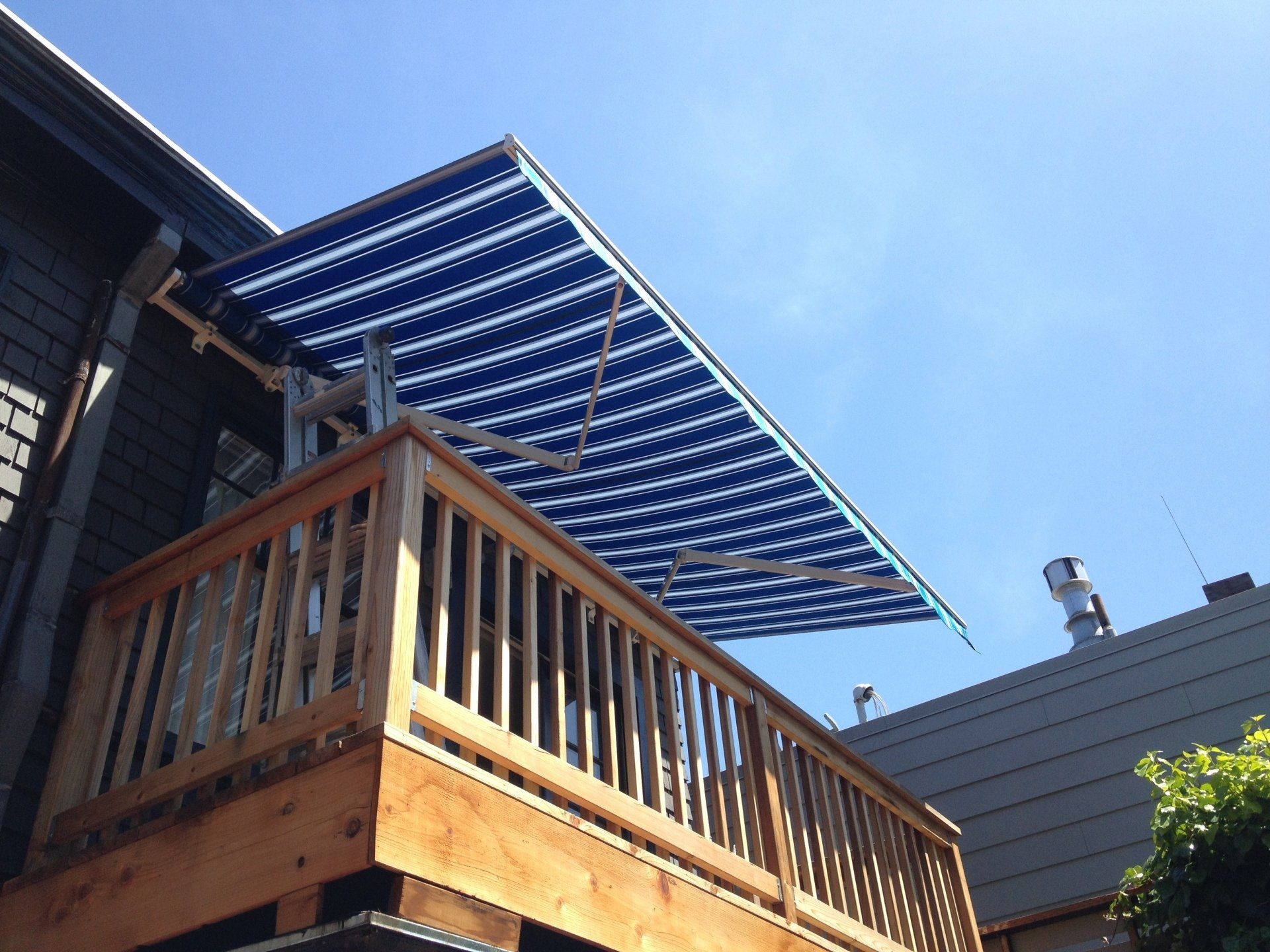 A balcony with a blue and white awning on it