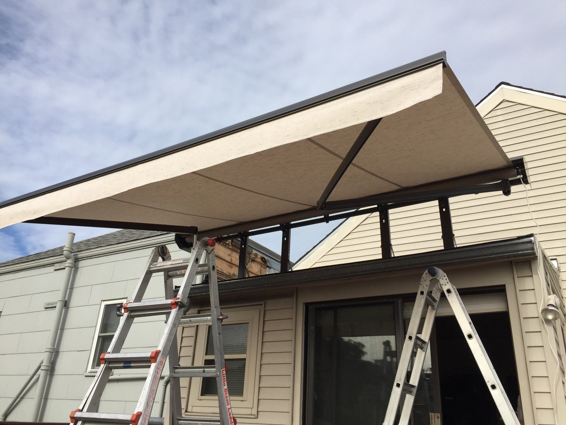 An awning is being installed on the side of a house