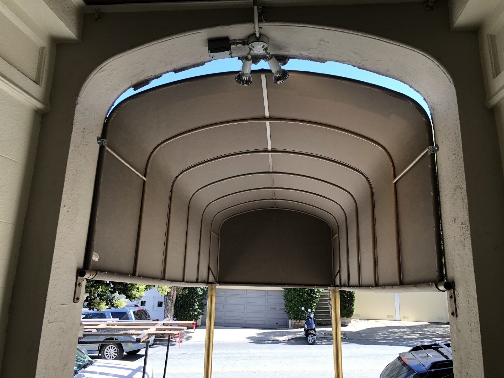 A car is parked under a canopy in a garage