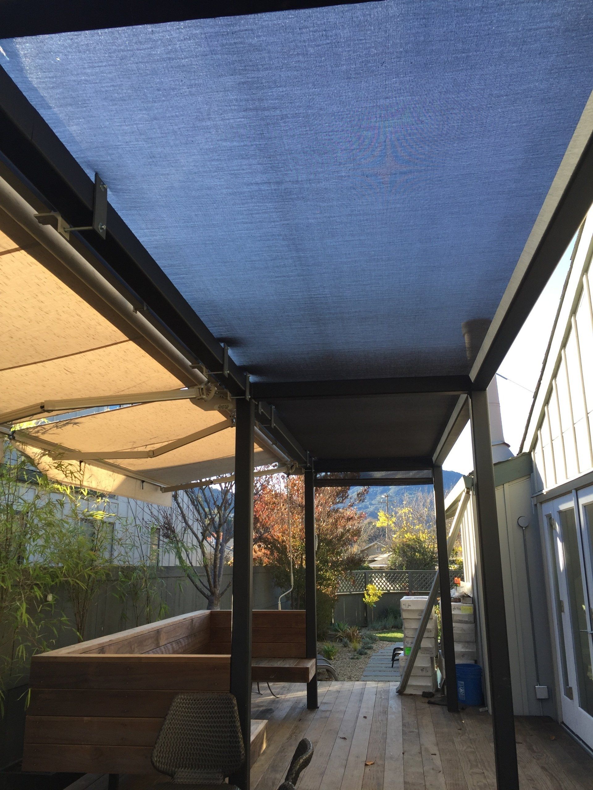 A wooden deck with a blue awning over it