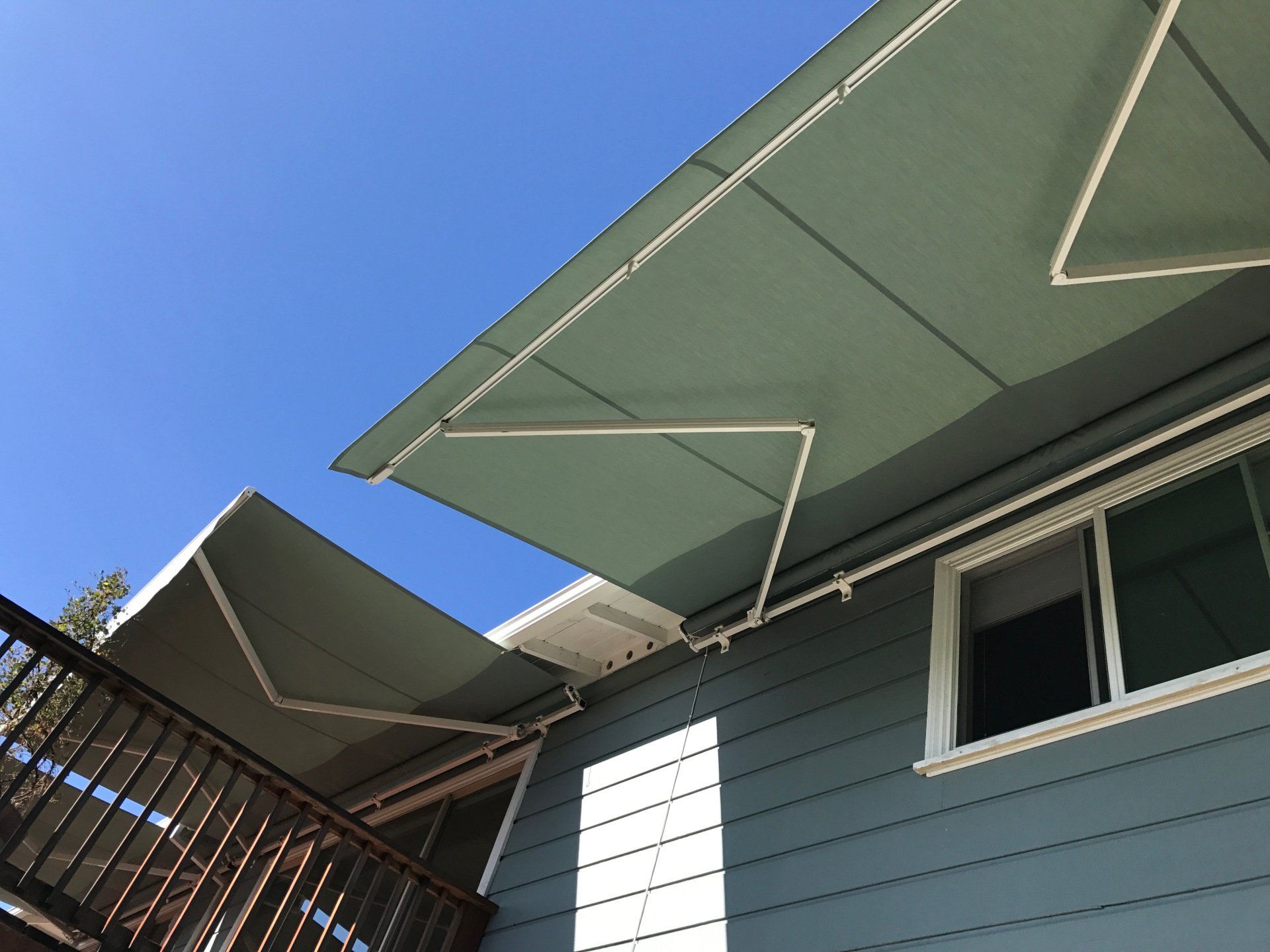 A house with a green awning on the side of it
