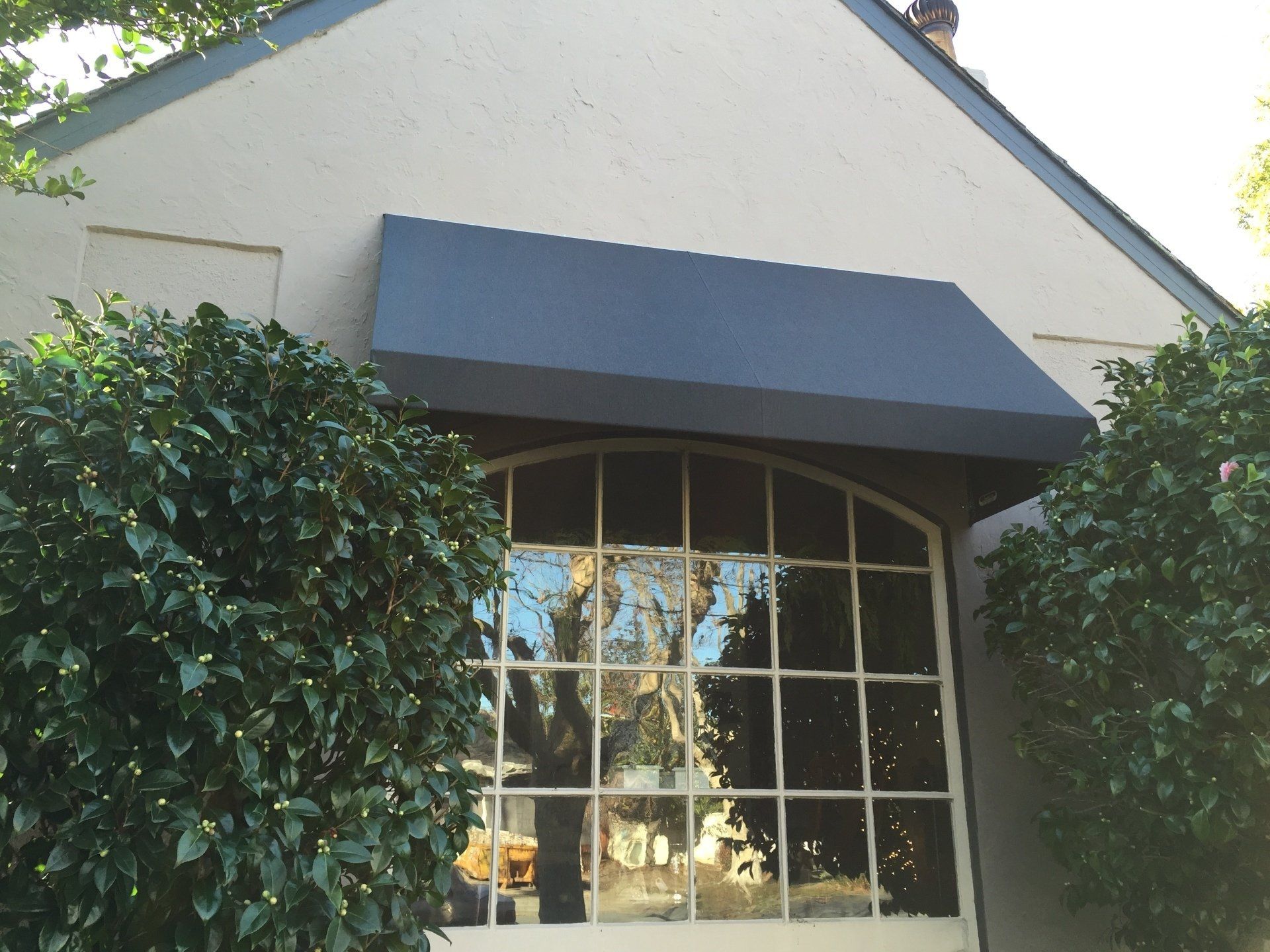 A house with a blue awning over a large window