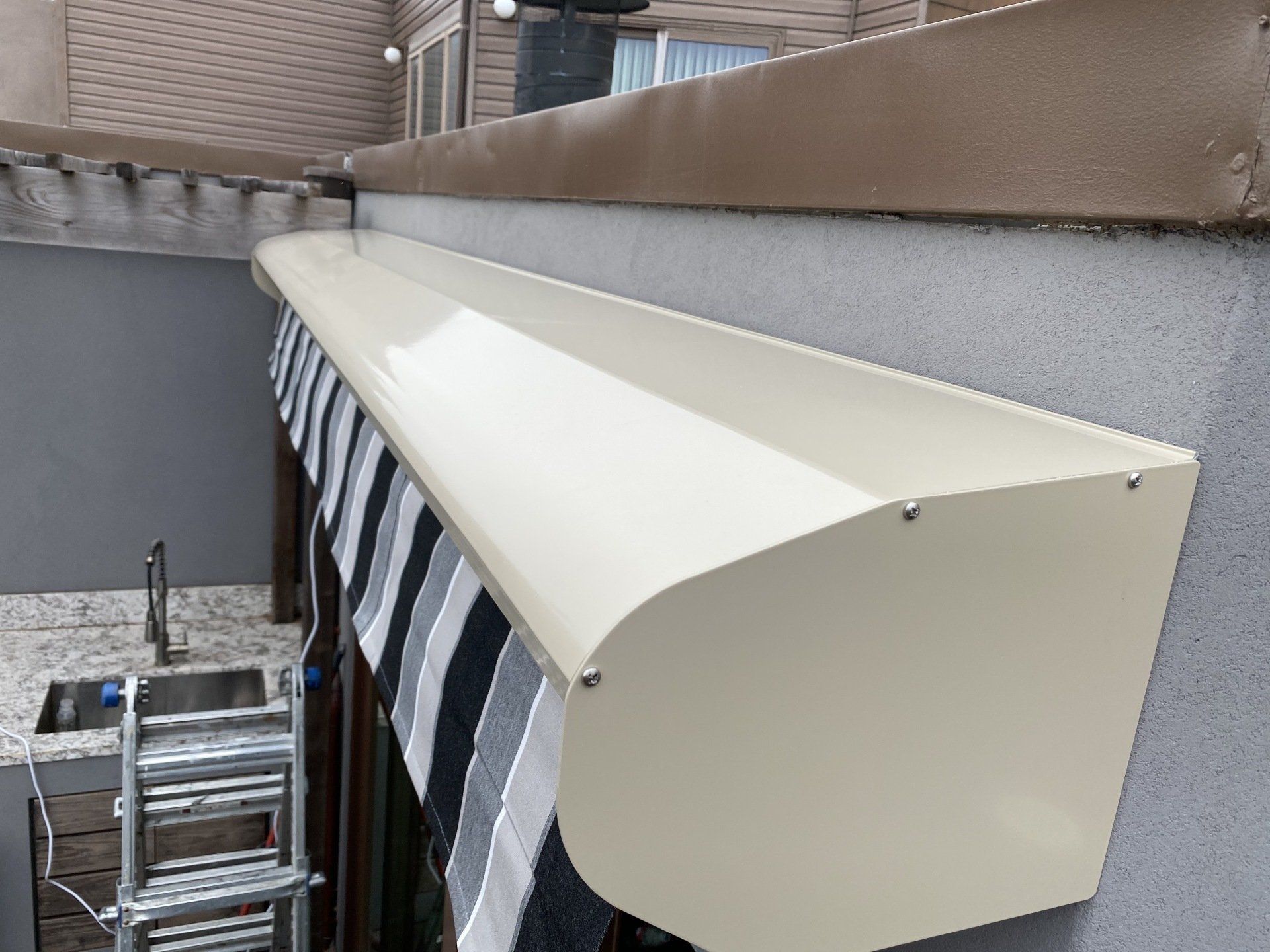 A white awning is attached to the side of a building.