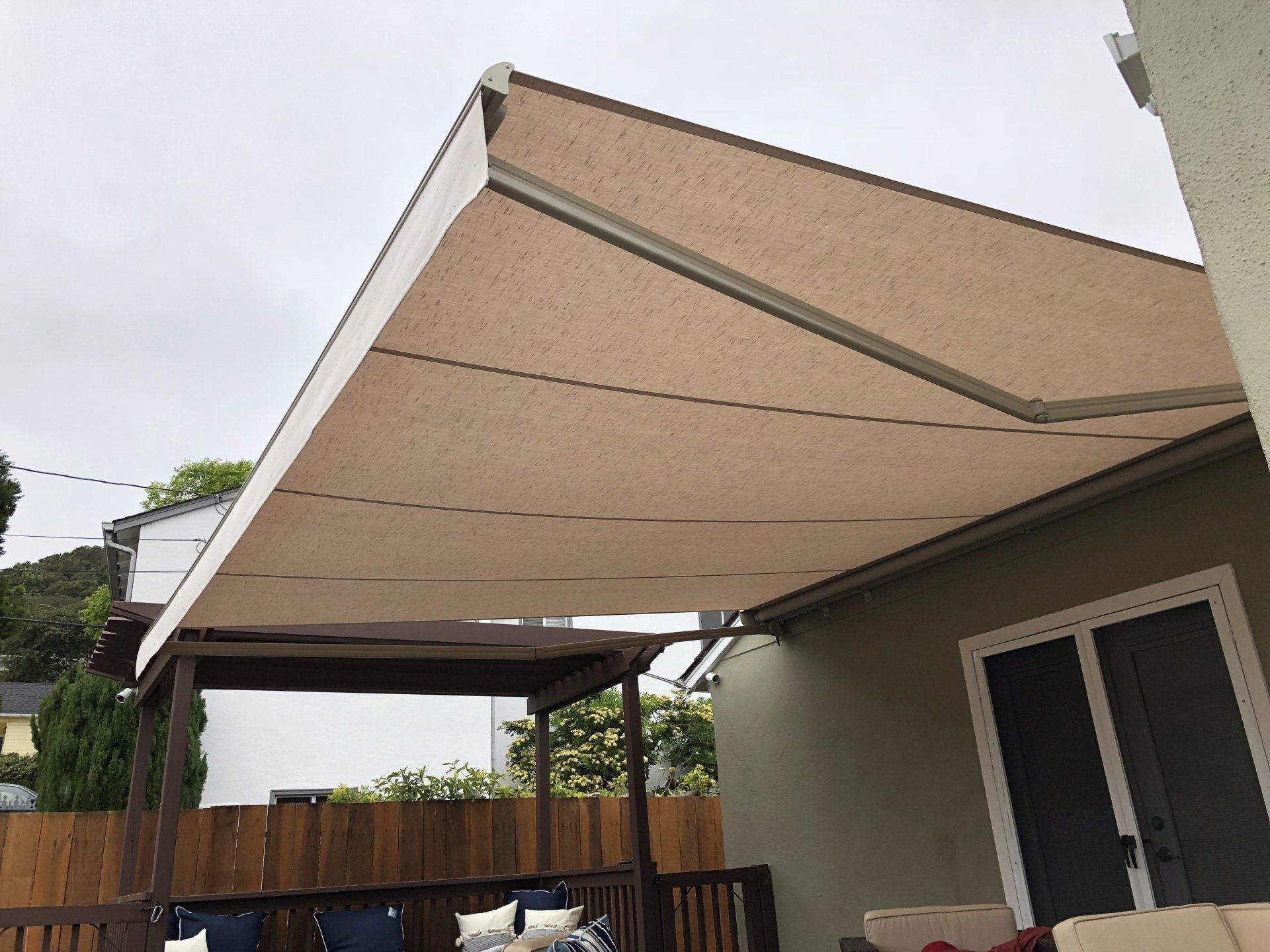 A large awning is covering a patio area in front of a house.