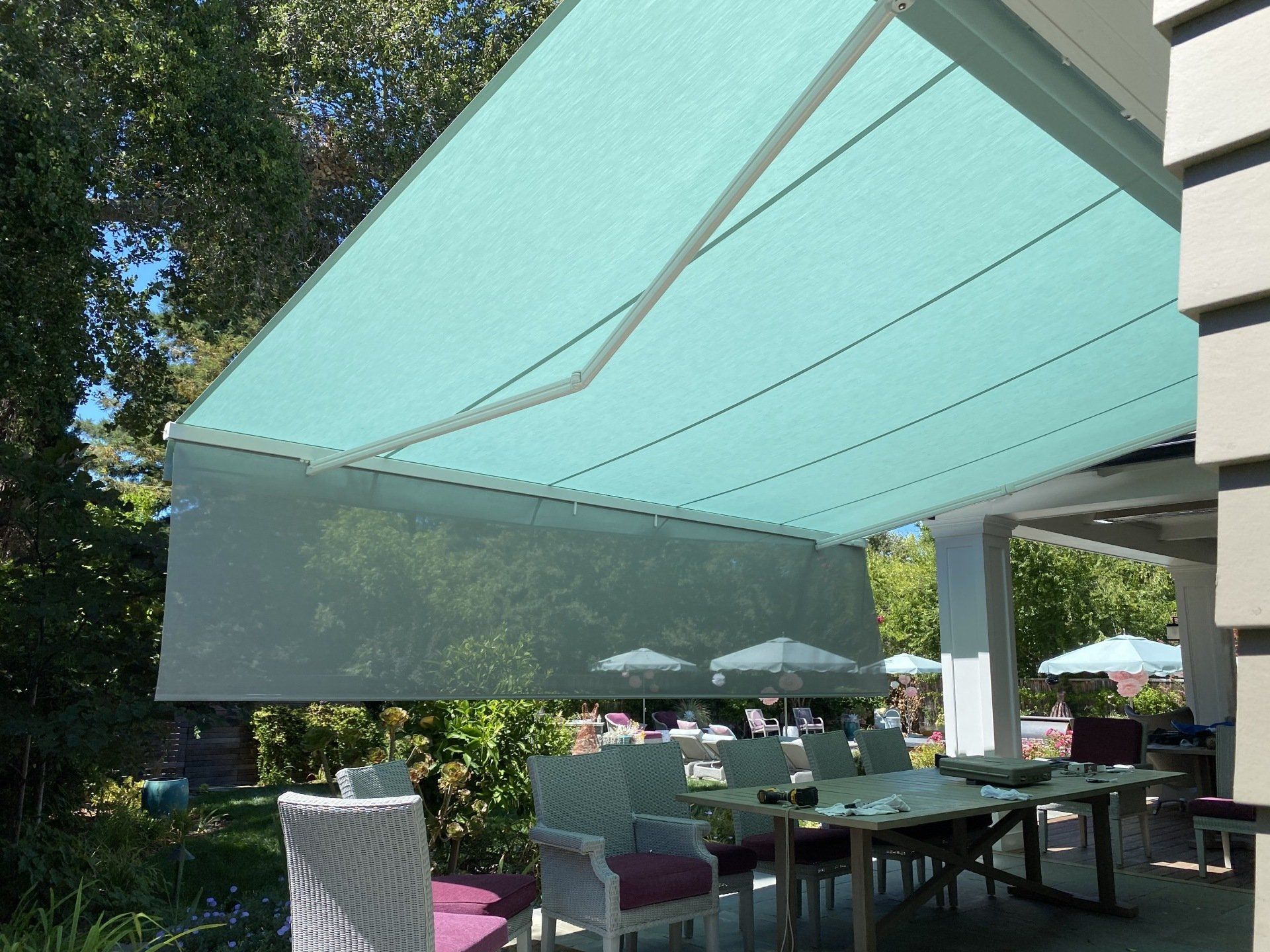 A patio with tables and chairs under an awning