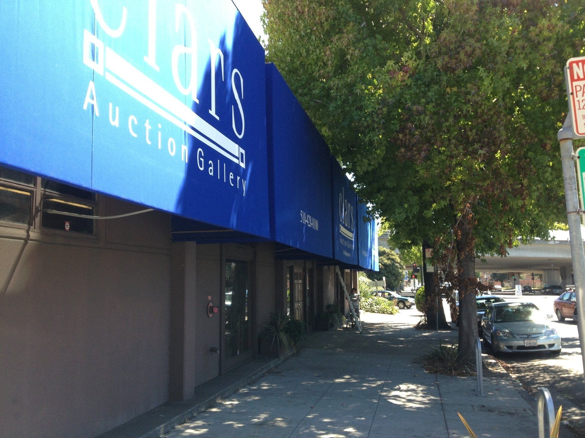 A building with a blue awning that says ' auction gallery ' on it