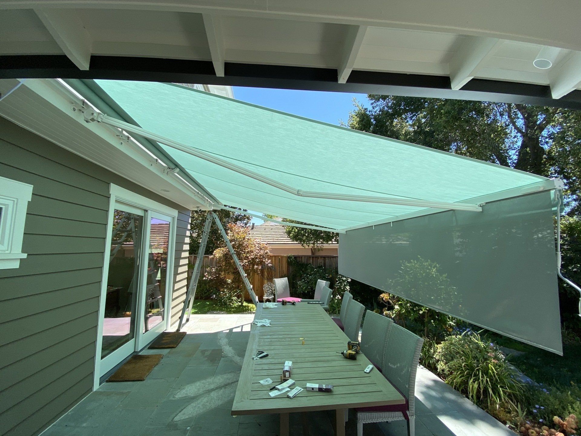 A patio with a table and chairs under an awning