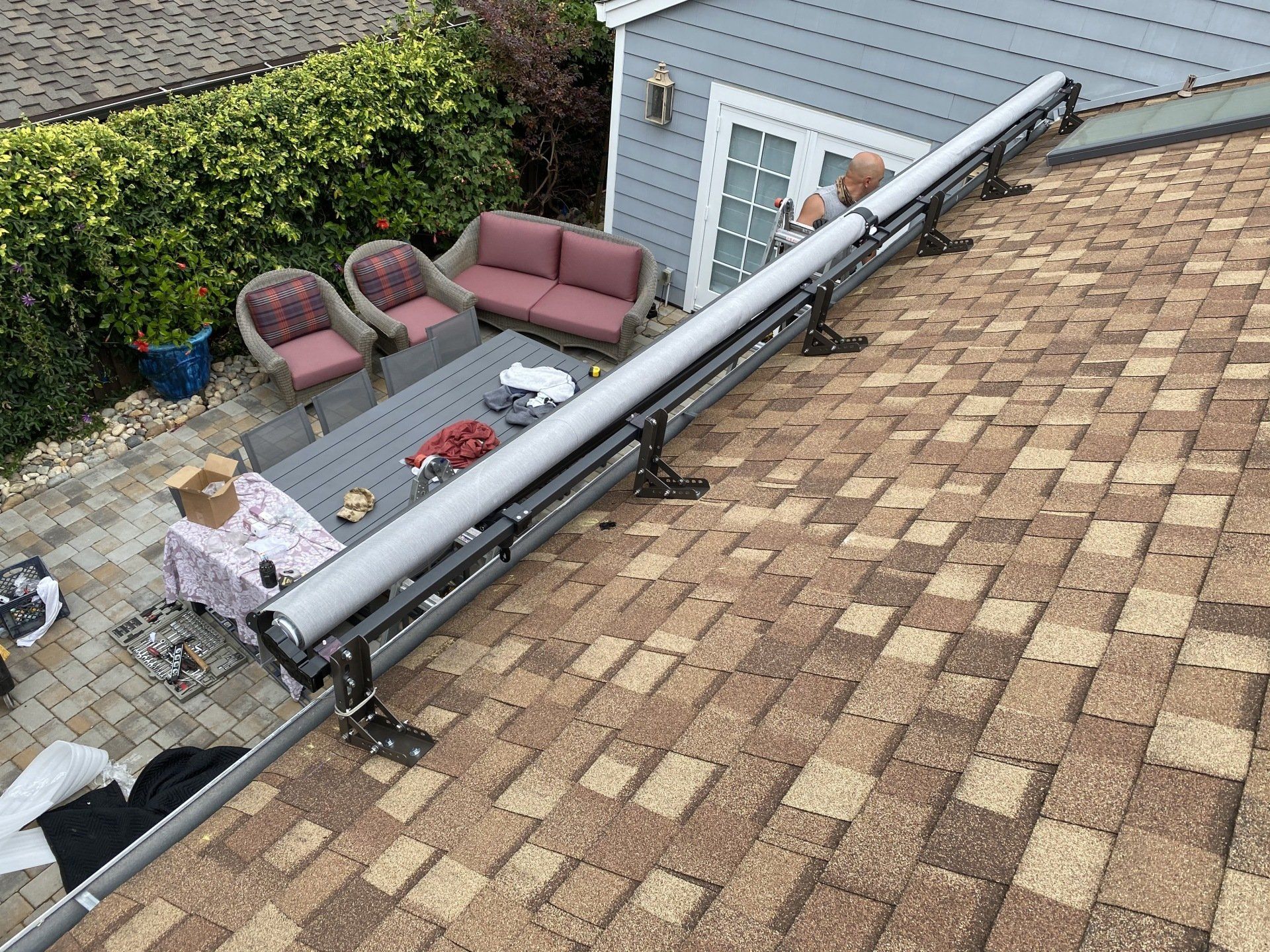 An aerial view of a roof with a table and chairs on it.