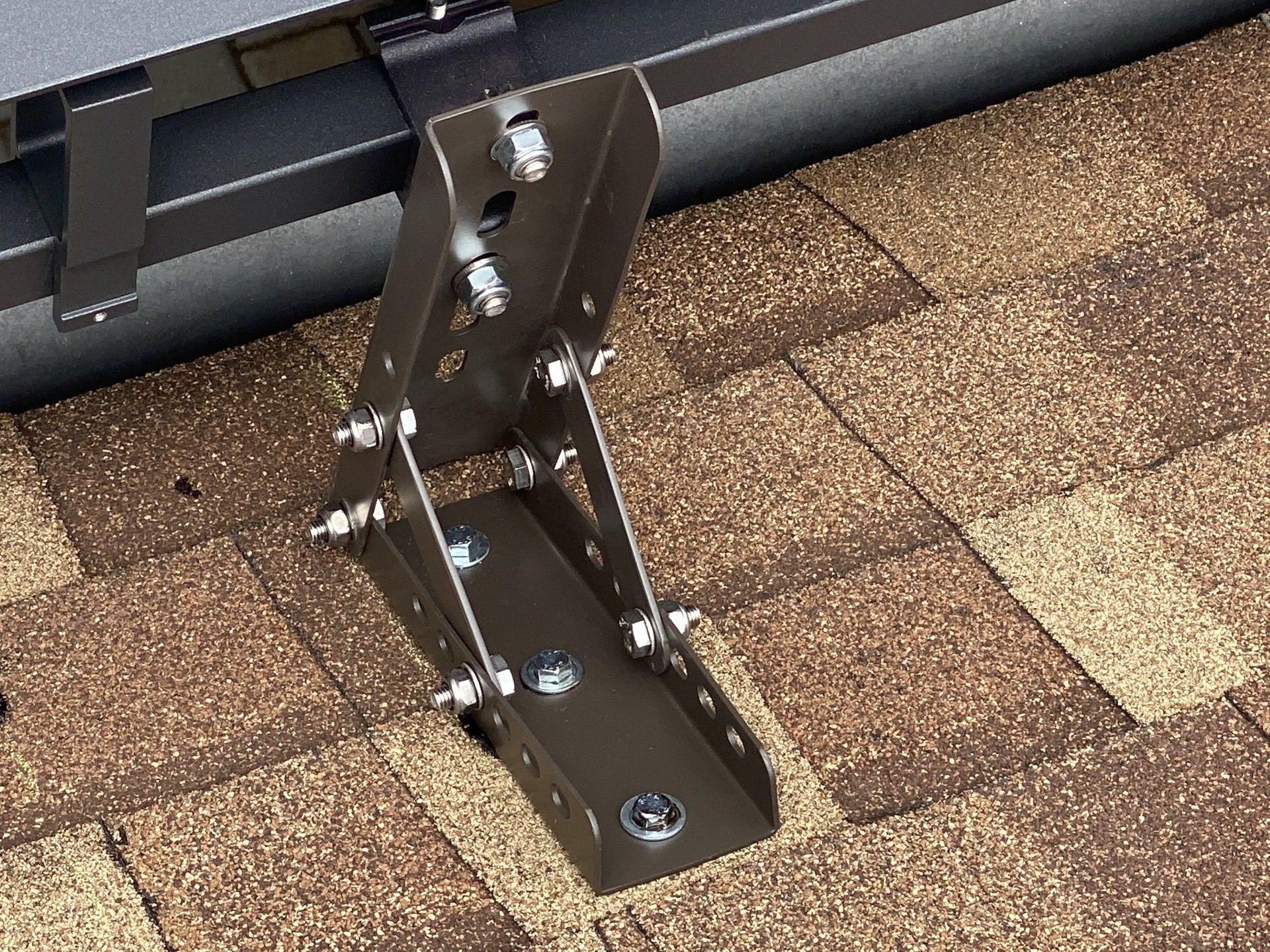 A metal bracket is attached to a brick roof