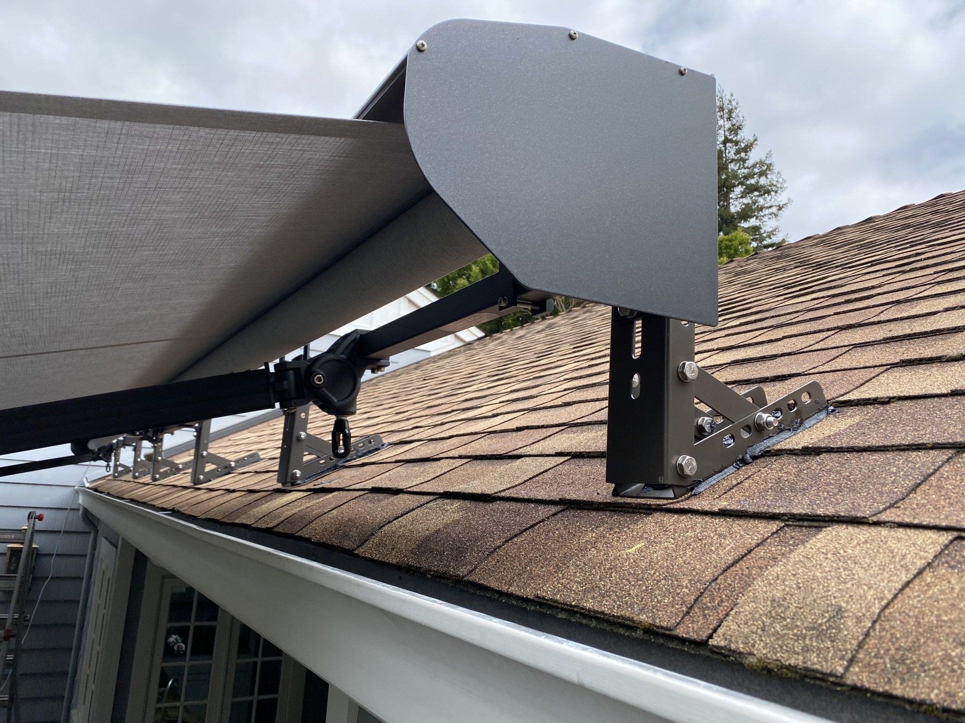 An awning is attached to the roof of a house