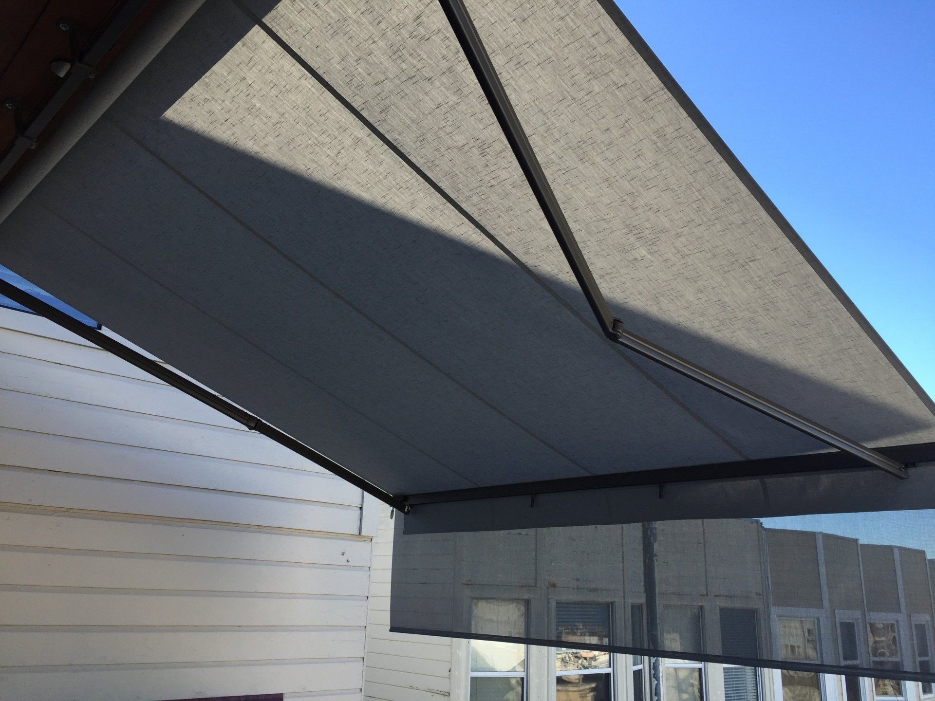 A white building with a gray awning over it