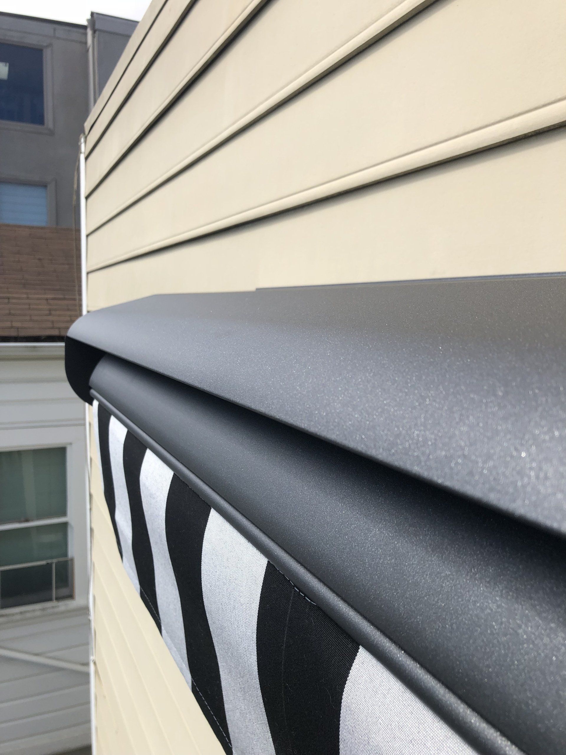 A black and white striped awning on the side of a house