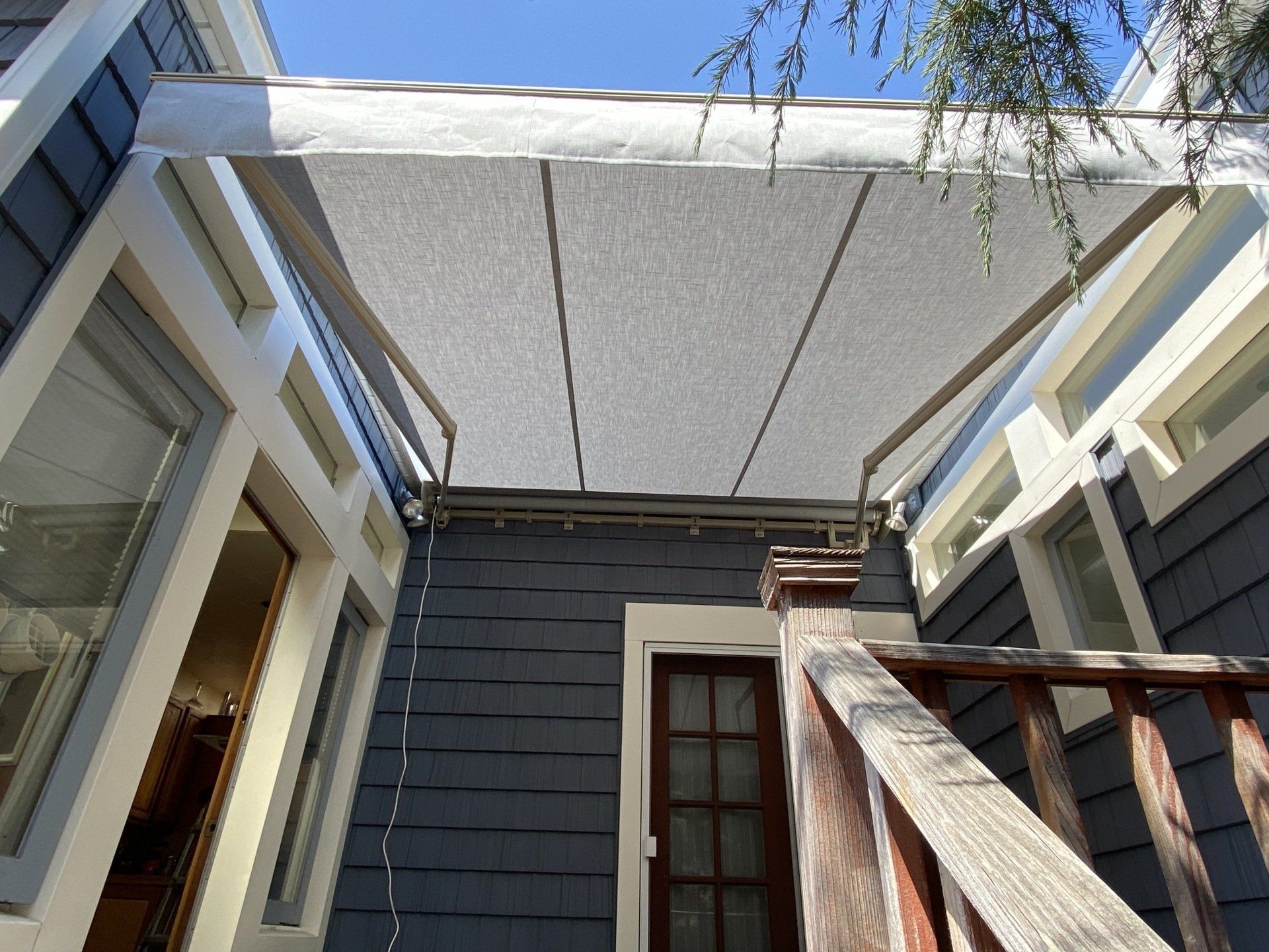 A white awning is hanging from the roof of a house