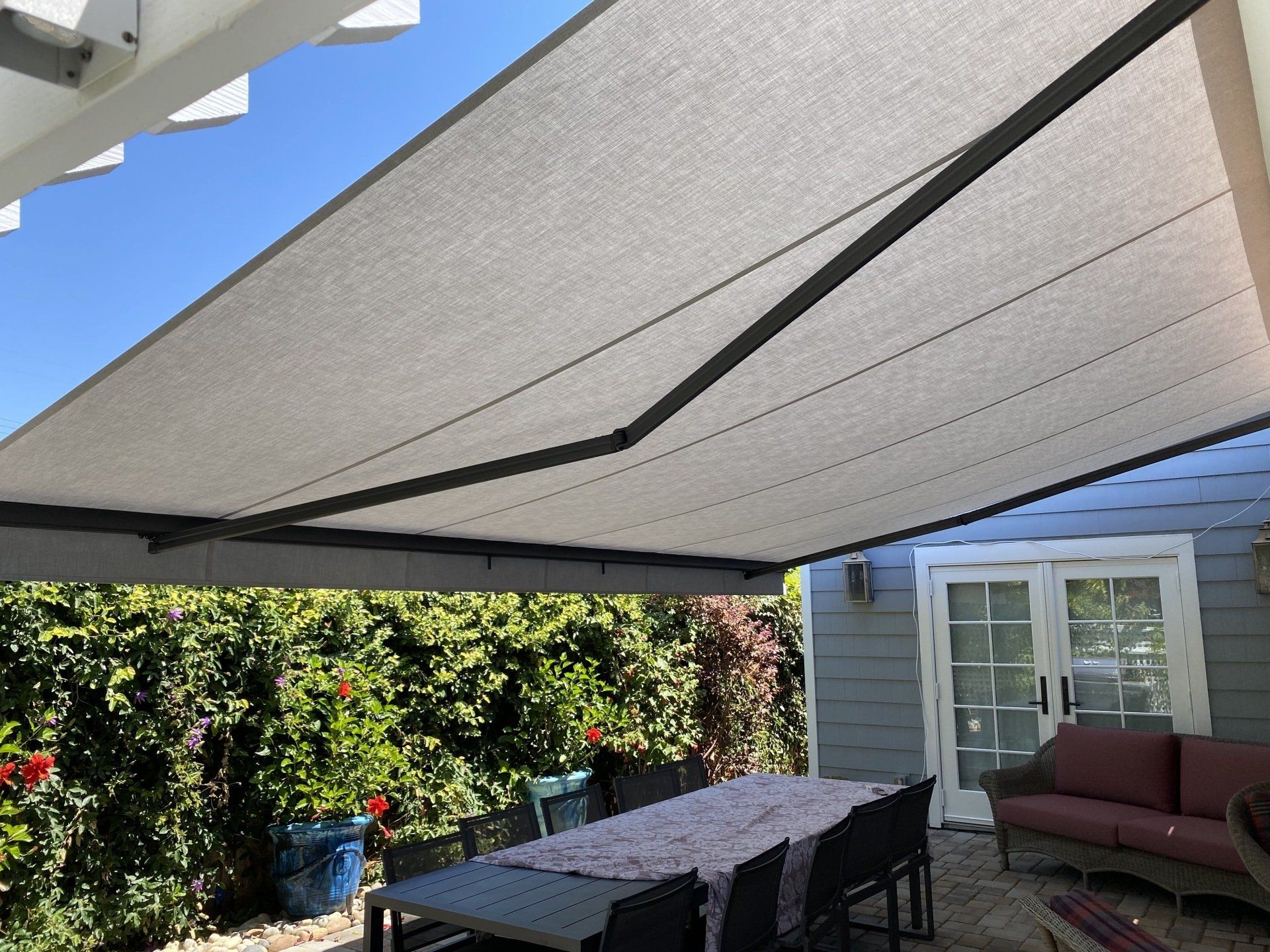 A patio with a table and chairs under an awning.